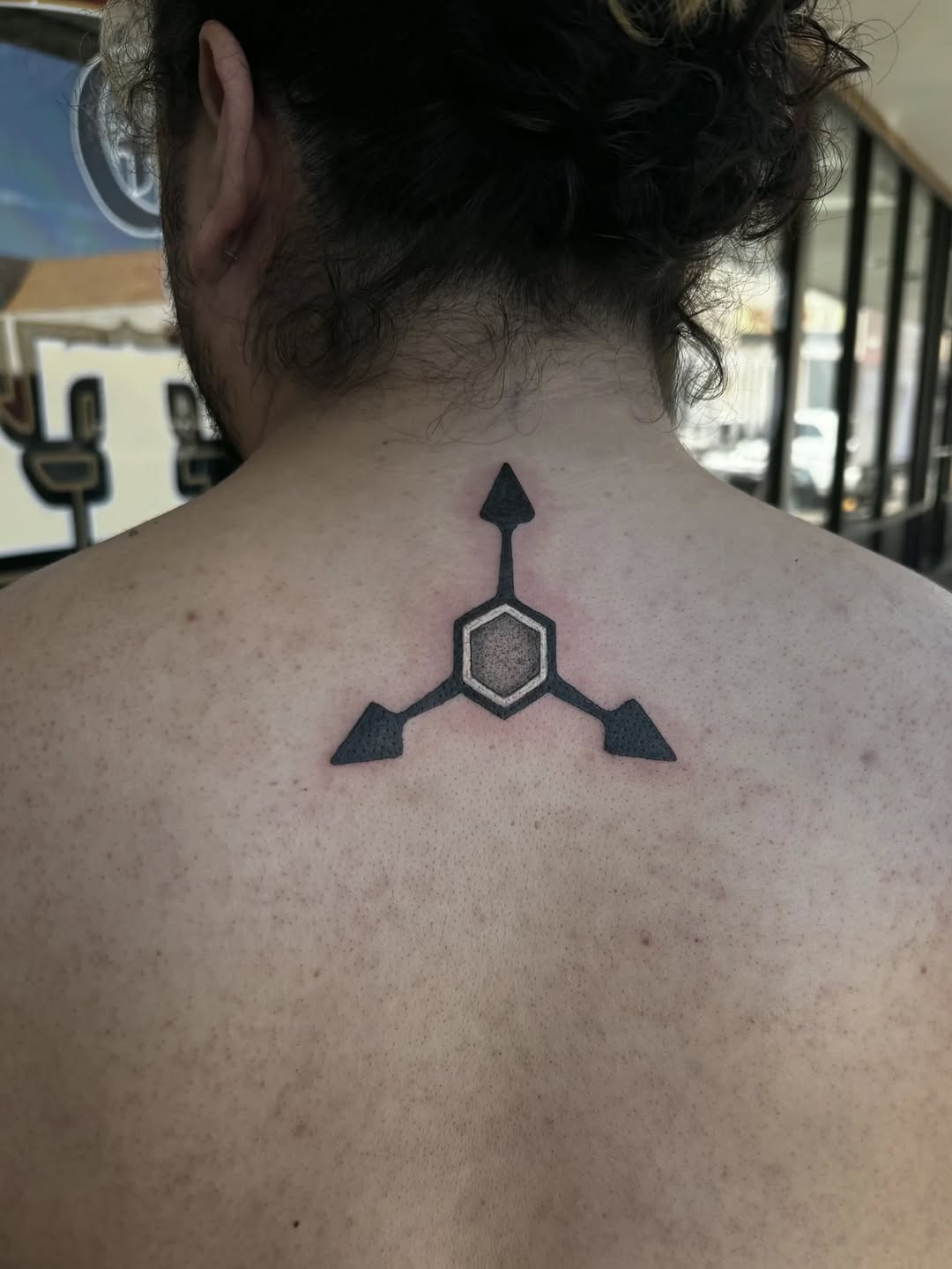 Geometric symbol with arrows blackwork tattoo on the back by Cielle
