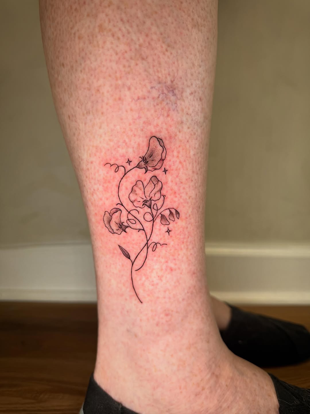 Sweet peas fine line tattoo on the calf by Danny Garcia