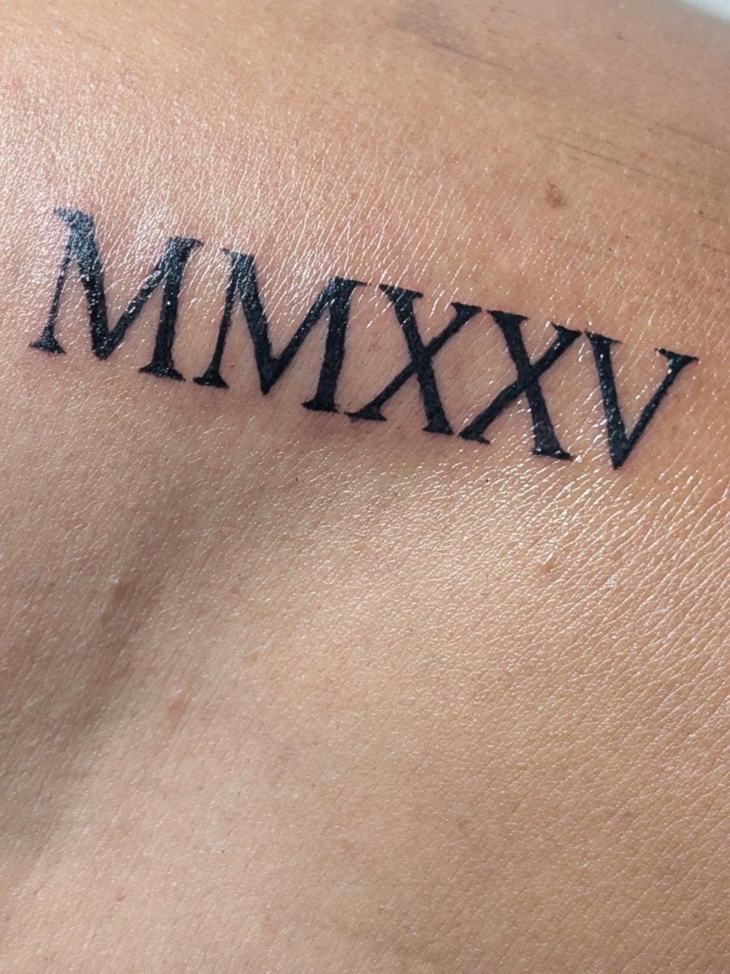 Roman numerals lettering script tattoo on the shoulder by Tony
