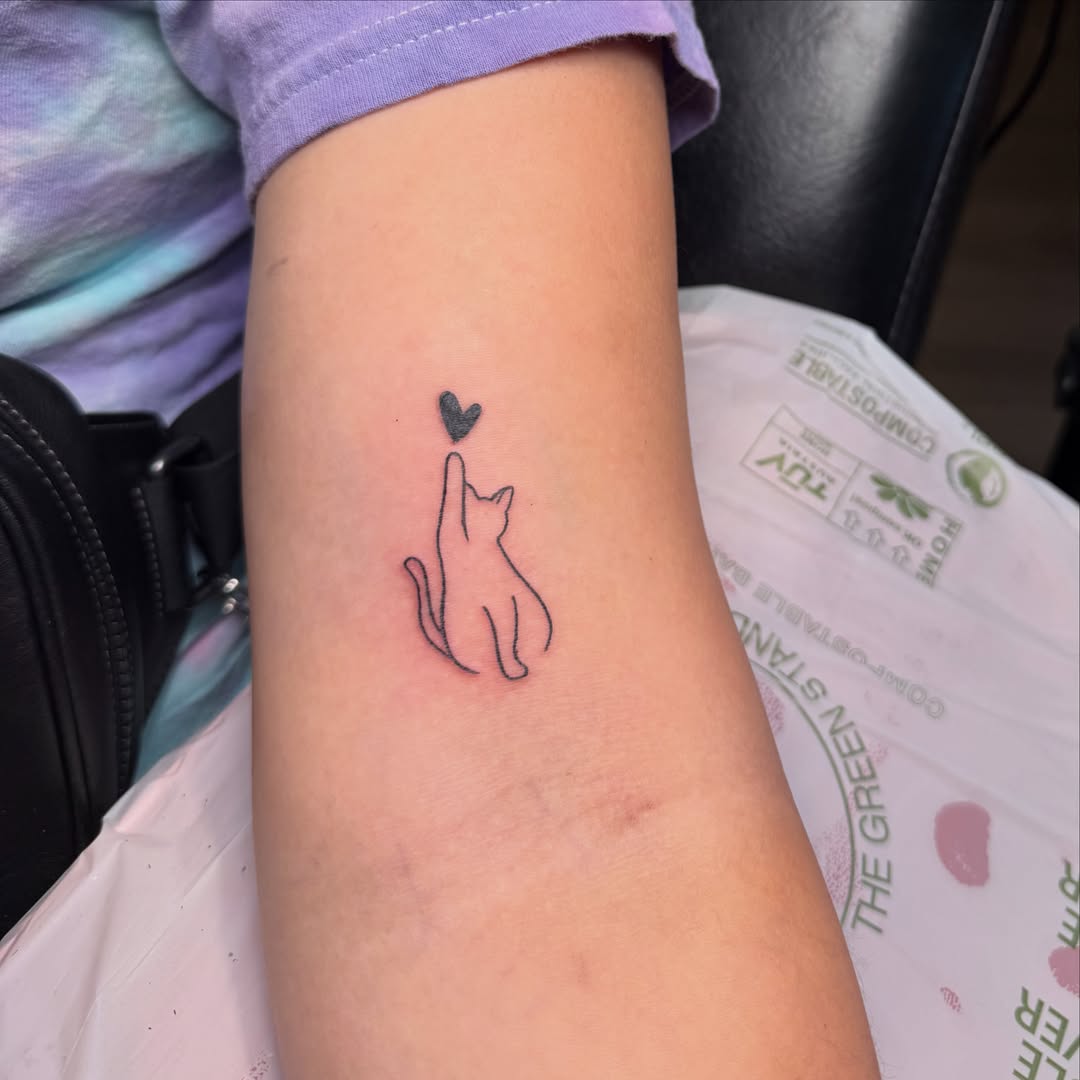 Cat silhouette minimalist tattoo on the forearm by Caroline at Lettie Grace Ink