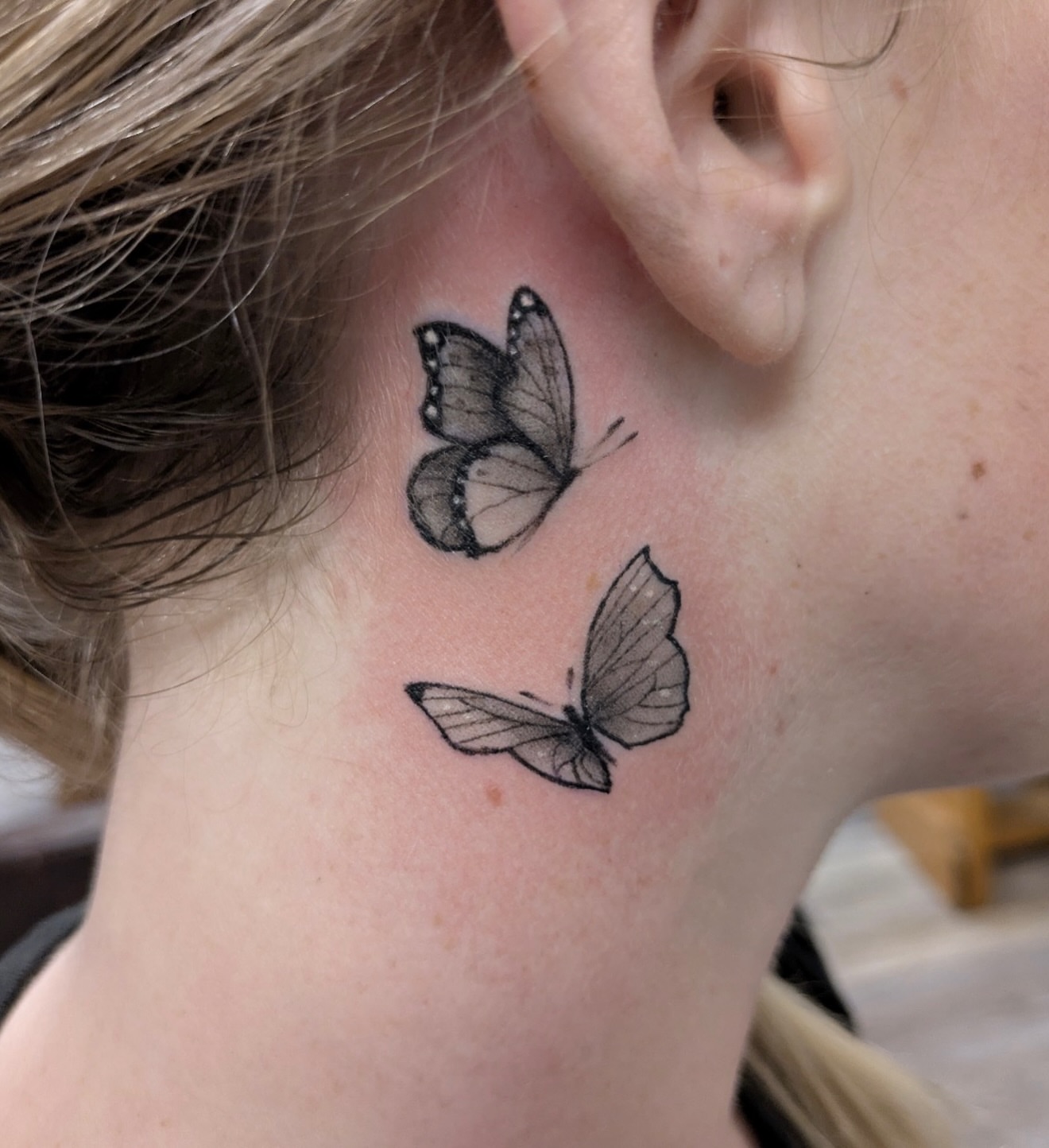 Butterflies black and grey tattoo on the neck by Buddy K.