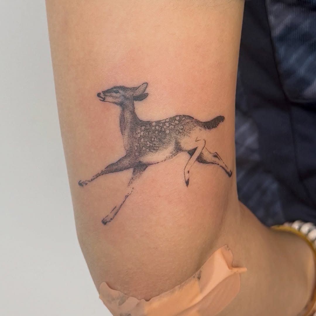 Running deer fine line tattoo on the forearm by Kirsten