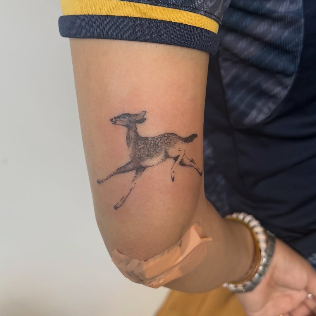 Running deer fine line tattoo on the forearm by Kirsten