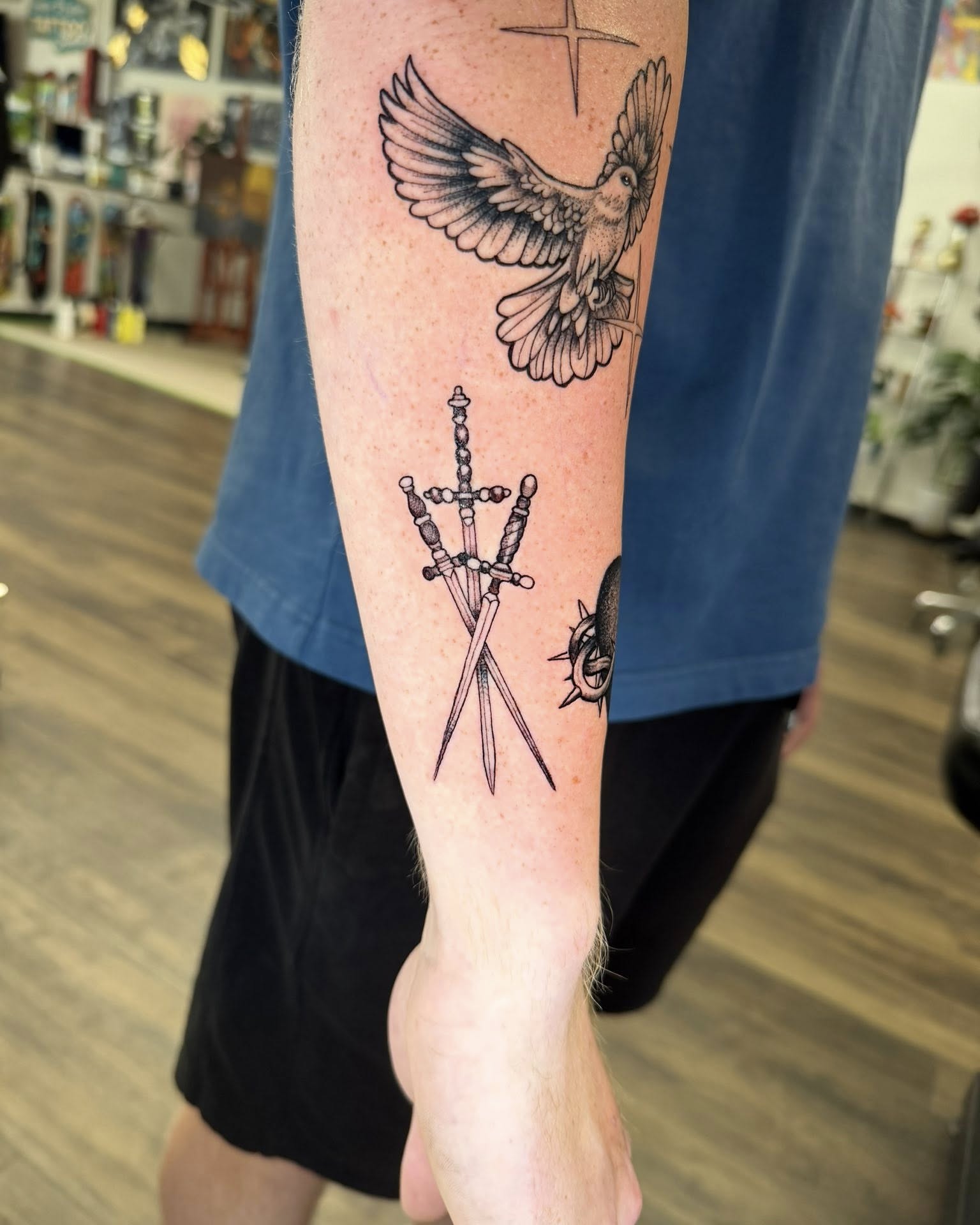 Bird and swords black and grey tattoo on the forearm by Chad Meado