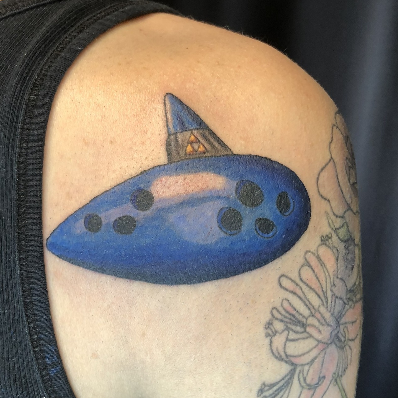 Blue ocarina geometric tattoo on the shoulder by Rowan Lee