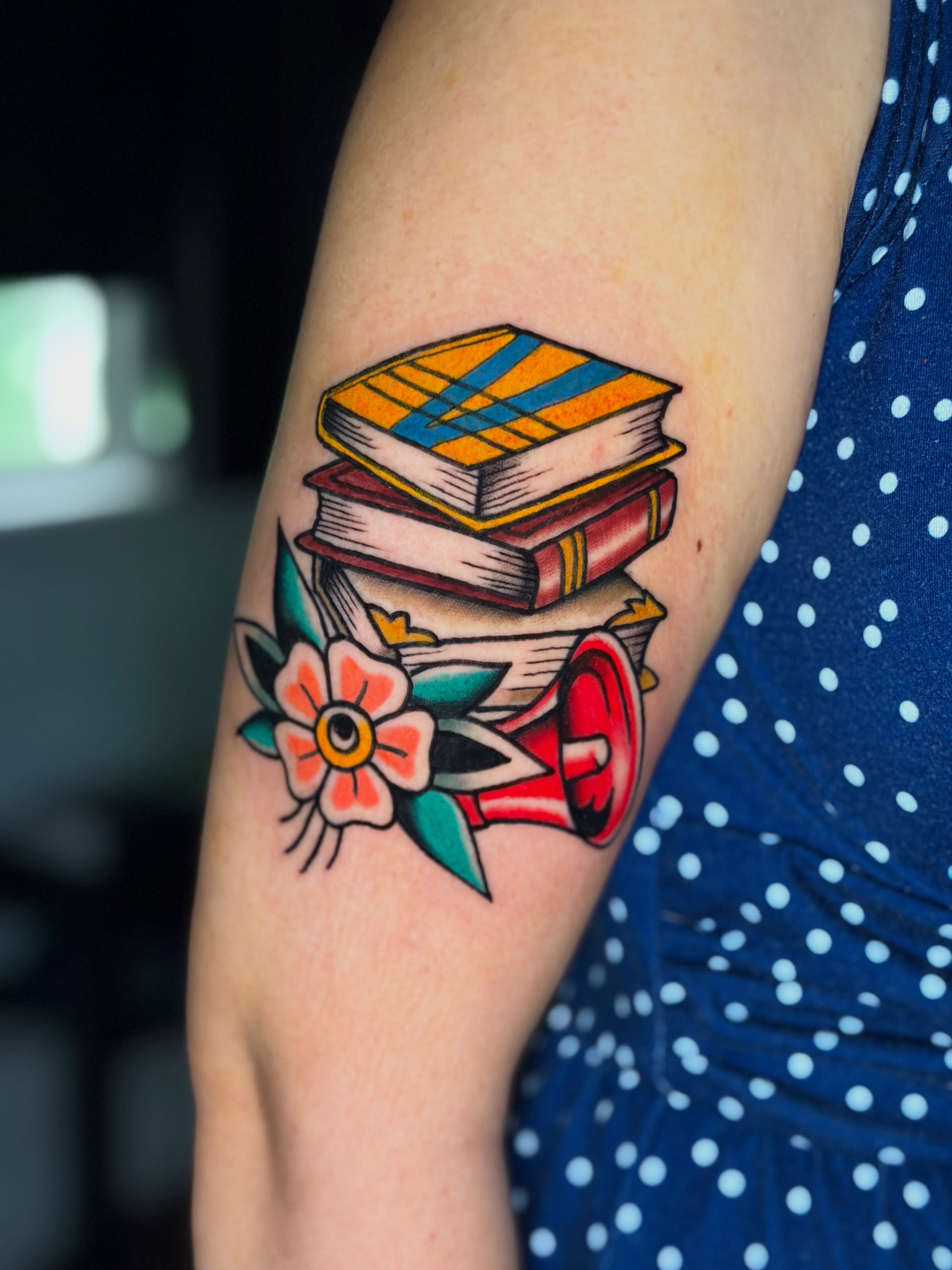 Stacked books and megaphone American traditional tattoo on the forearm by R e N O T