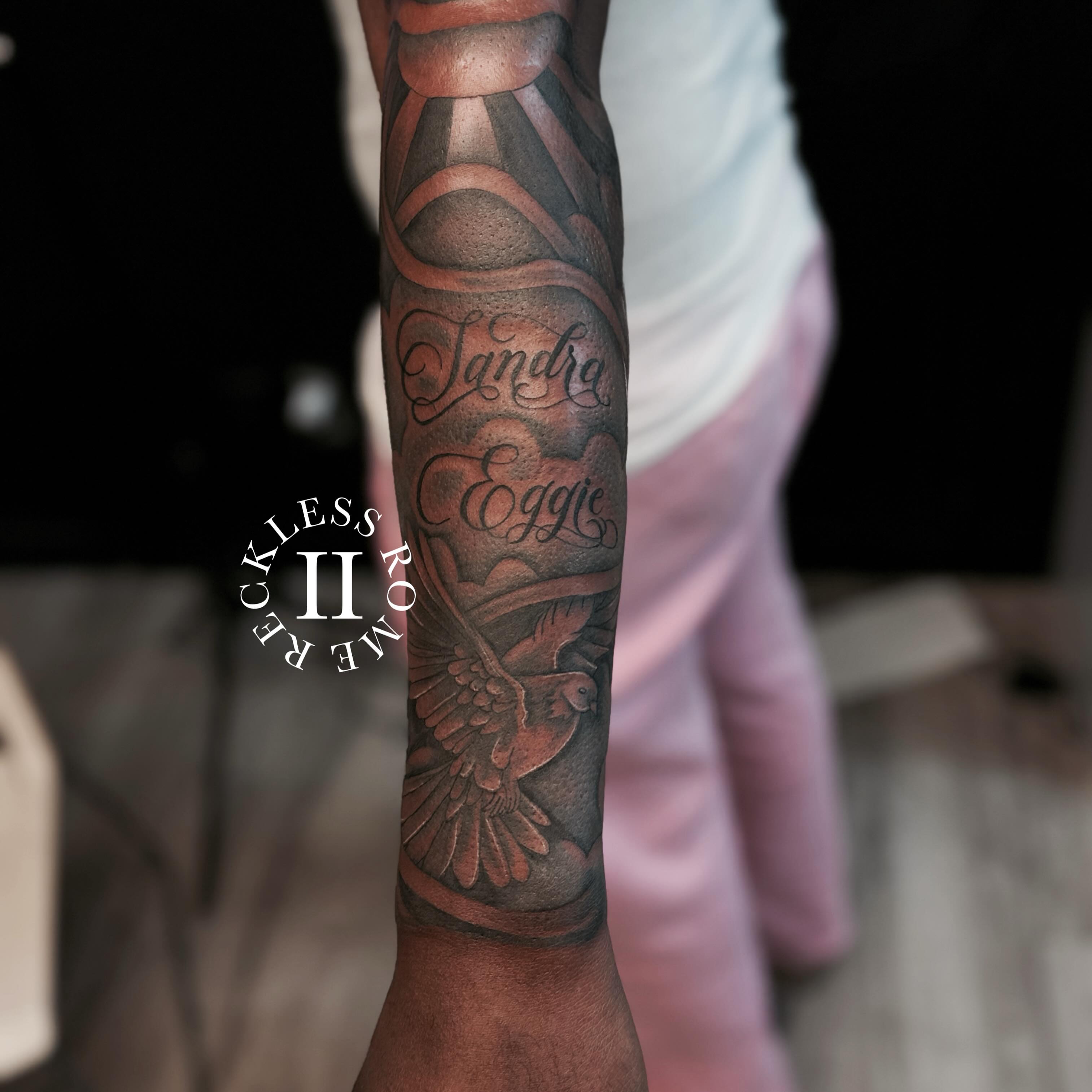 Bird and name black and grey tattoo on the forearm by Rome