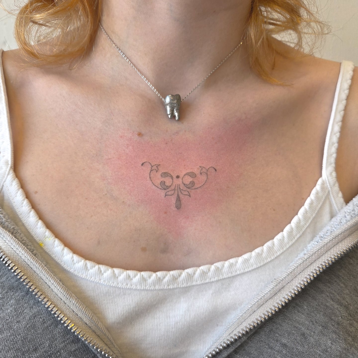 Scrollwork ornamental tattoo on the chest by jules tattoos