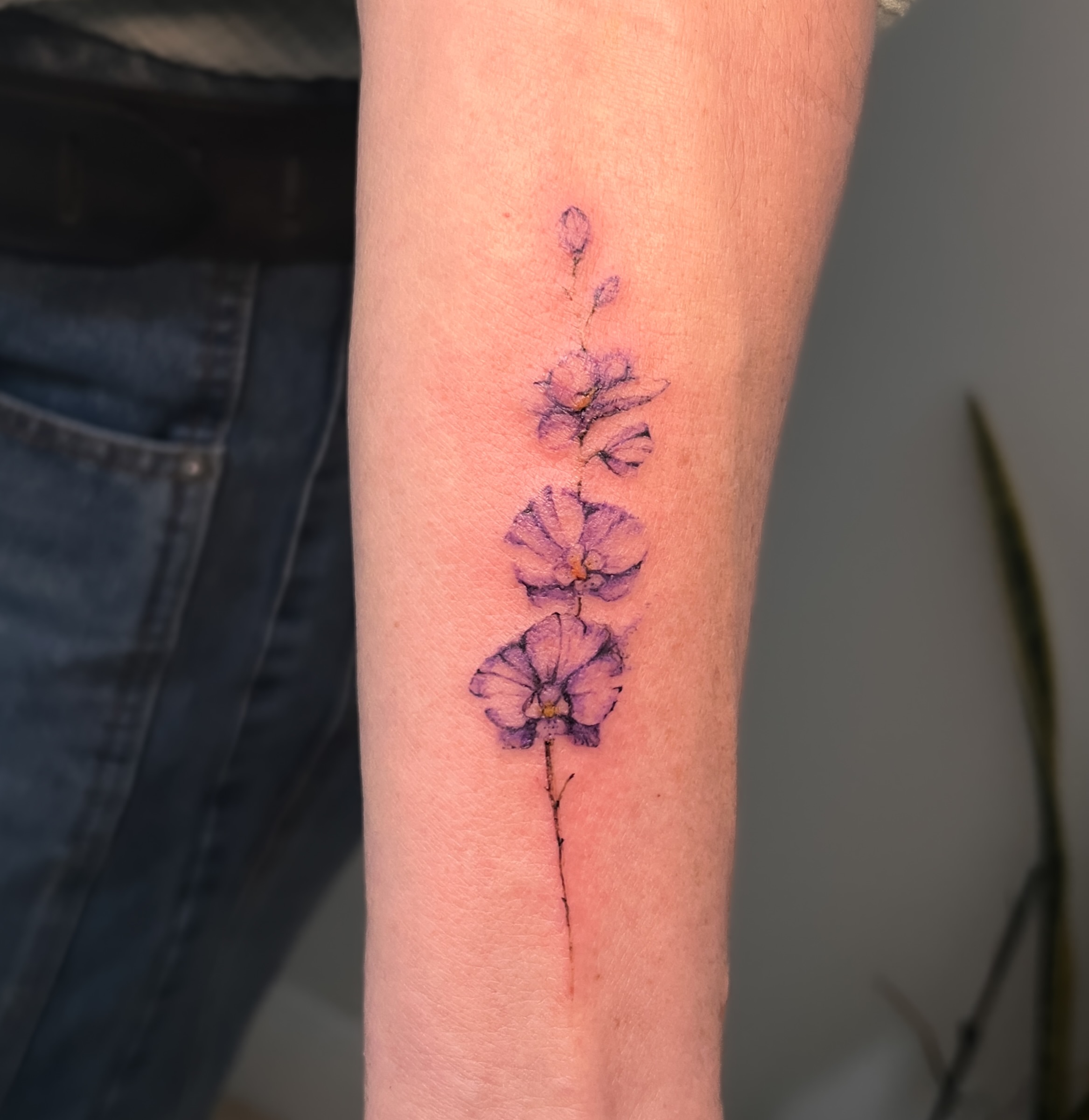 Purple flowers watercolor tattoo on the forearm by Eleana, North Miami, Florida