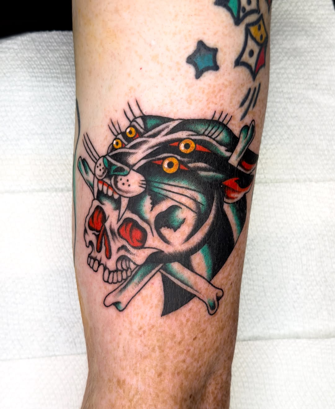 Skull and cat American traditional tattoo on the forearm by Allie Barringer