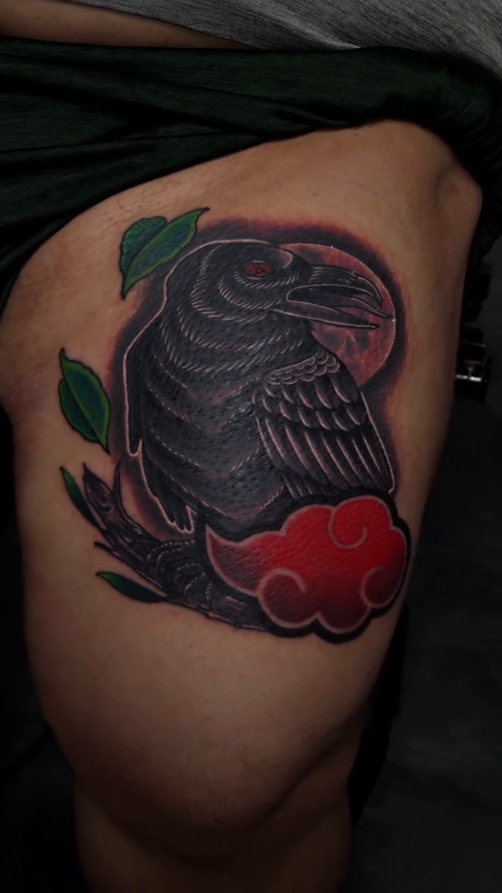 Raven with red clouds realism tattoo on the thigh by Joey Vinci, Phoenix, Arizona