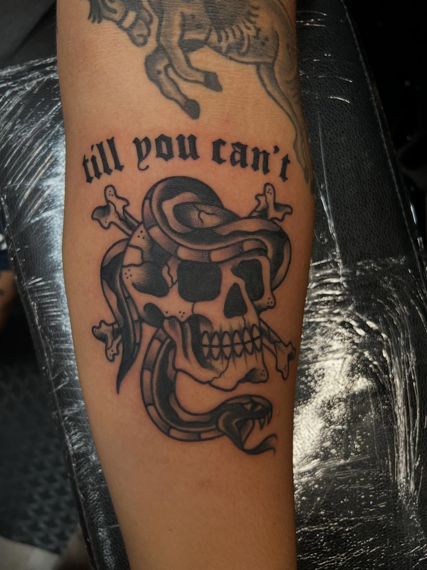 Skull with snake black and grey tattoo on the forearm by Tyler Van Pelt