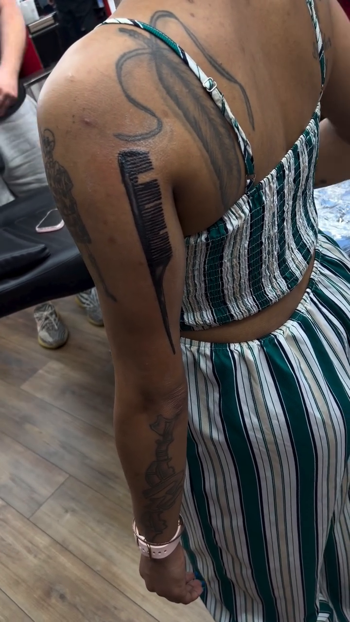 Comb with flowing hair lettering tattoo on the back by Mike Tatts