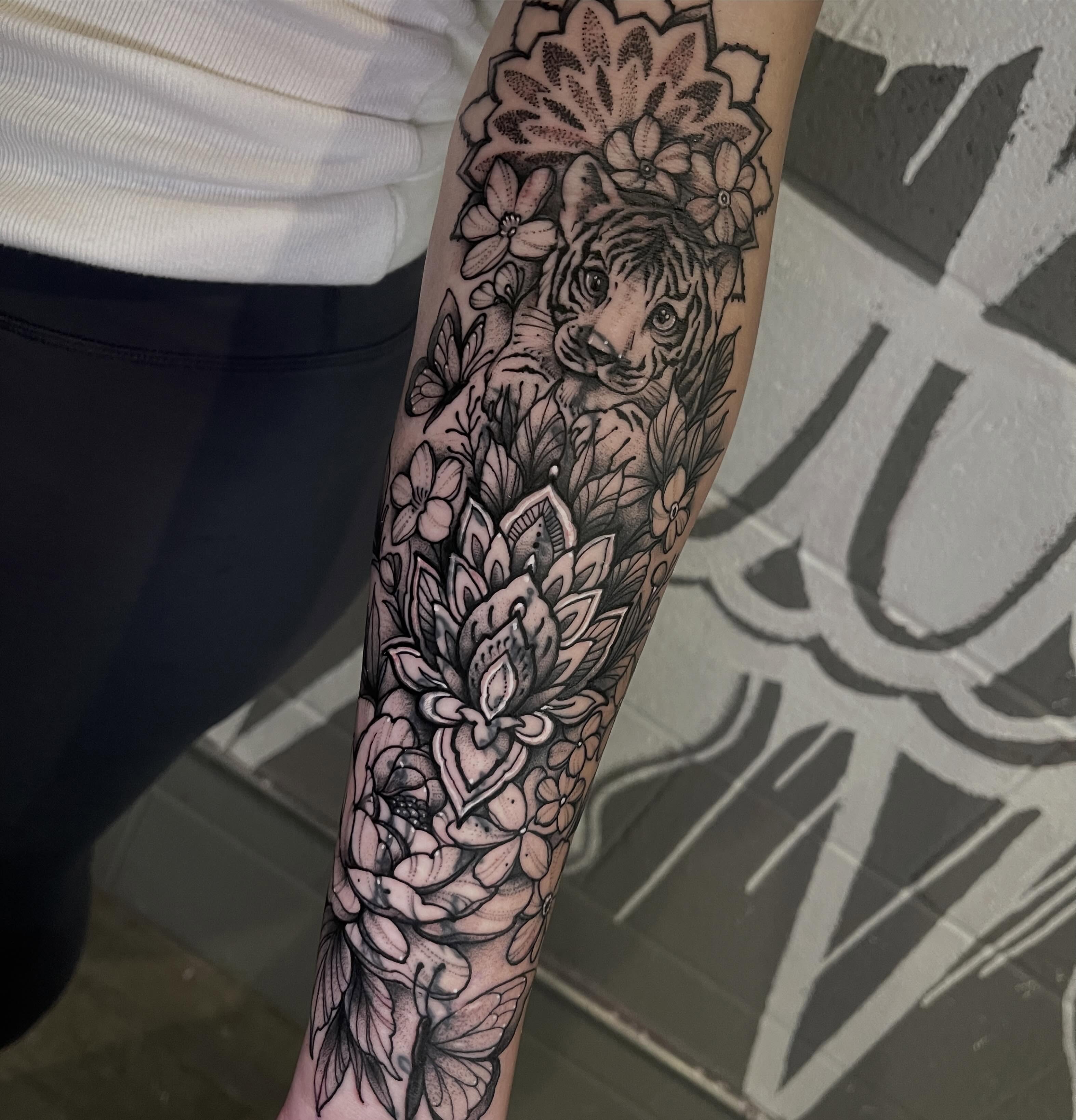 Tiger and floral realism tattoo on the forearm by Brandon Mola, Chicago, Illinois