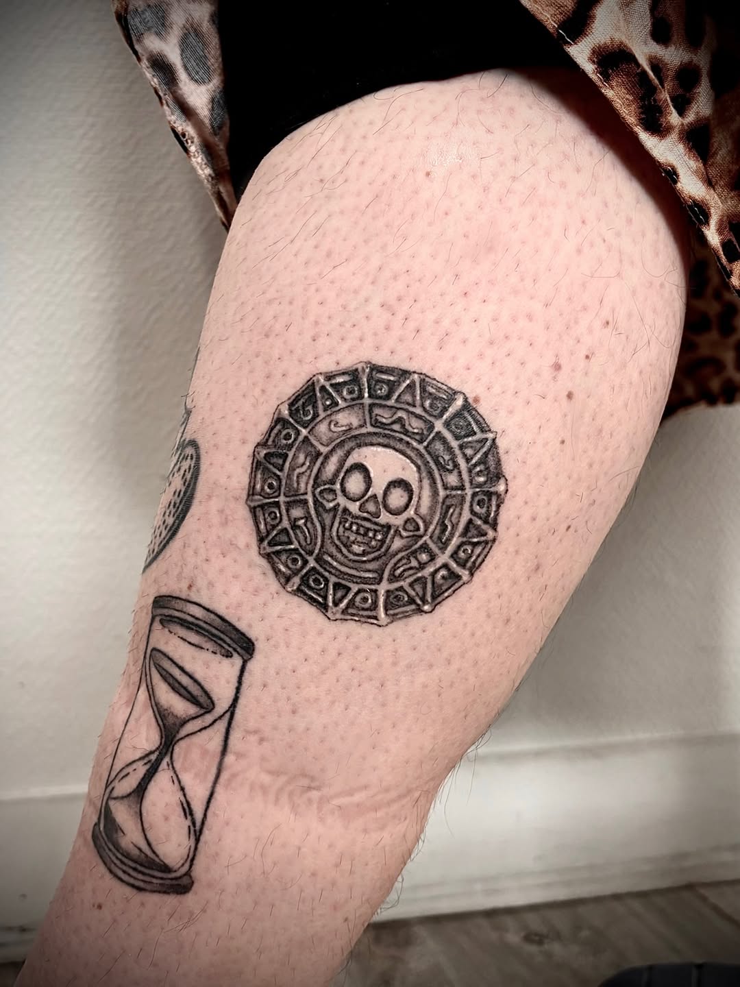 Aztec coin and hourglass realism tattoo on the forearm by Deborah