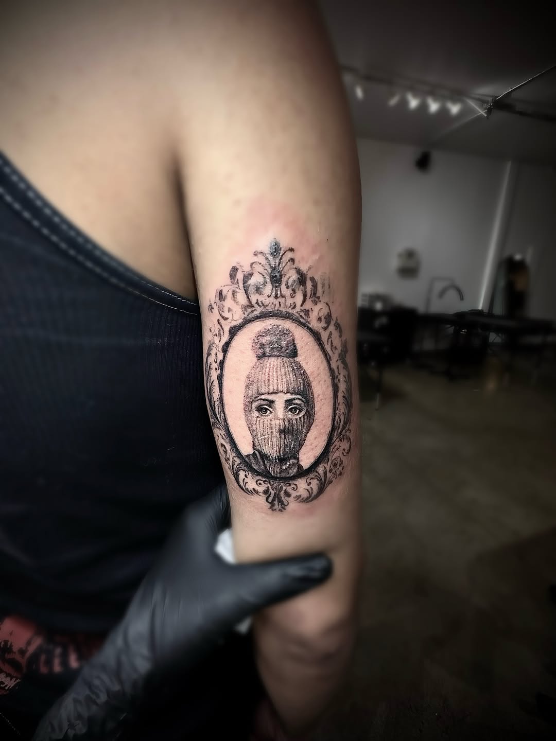 Portrait in ornate frame realism tattoo on the forearm by Ava De La Torre