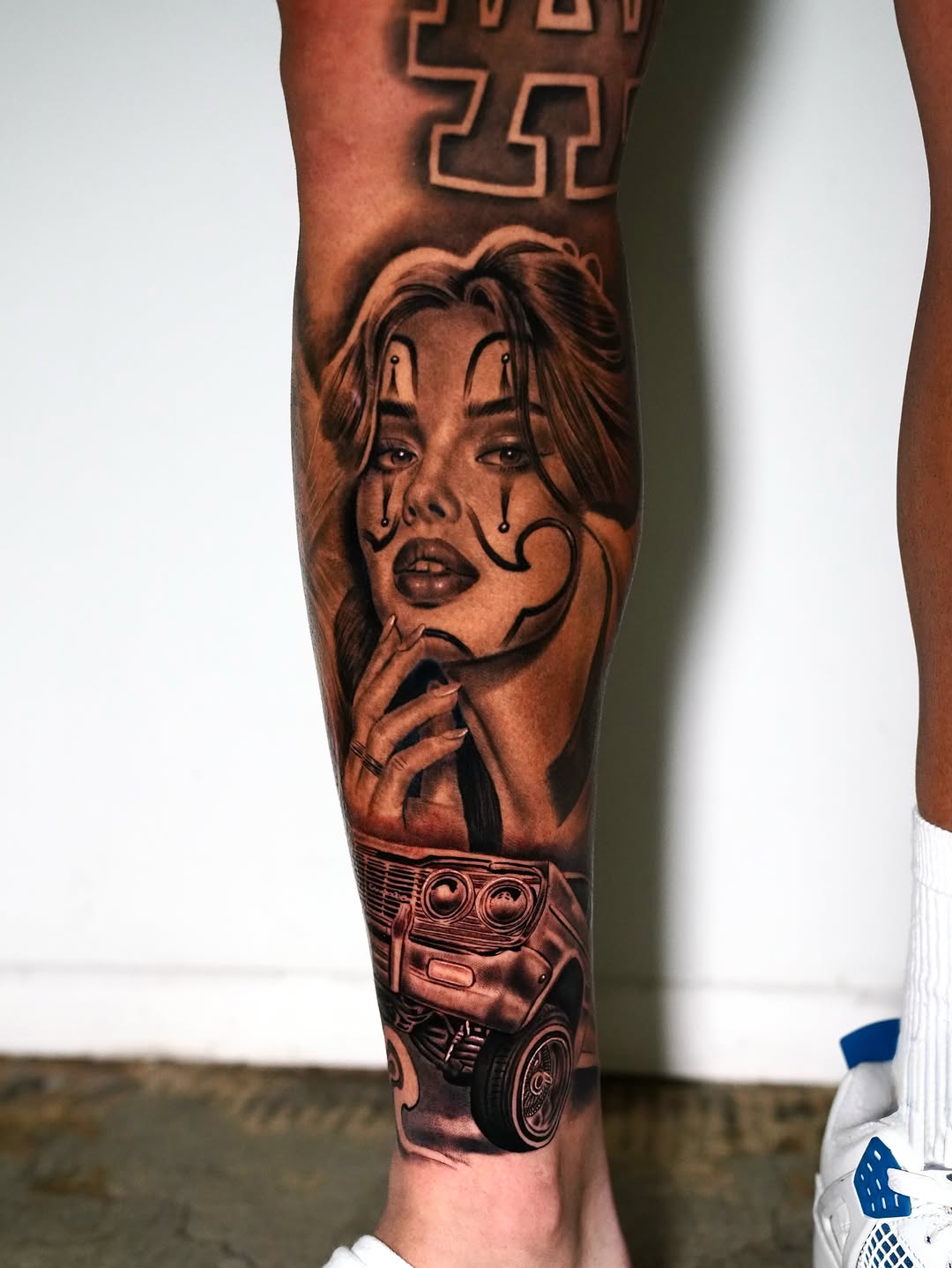 Chola clown girl and lowrider car Chicano tattoo on the calf by Luis Peña