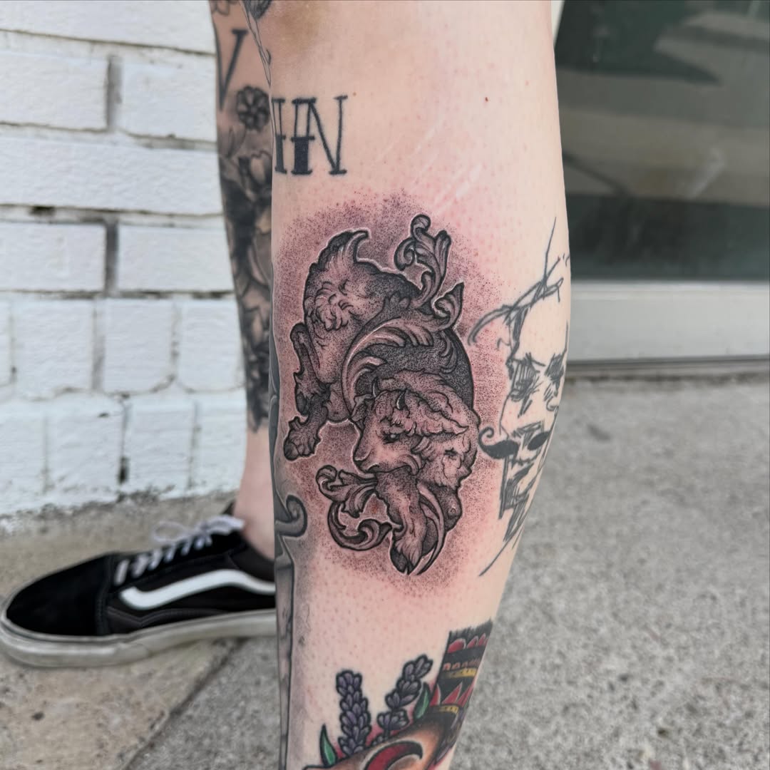 Lion and skull black and grey tattoo on the forearm by Alex Wheelock