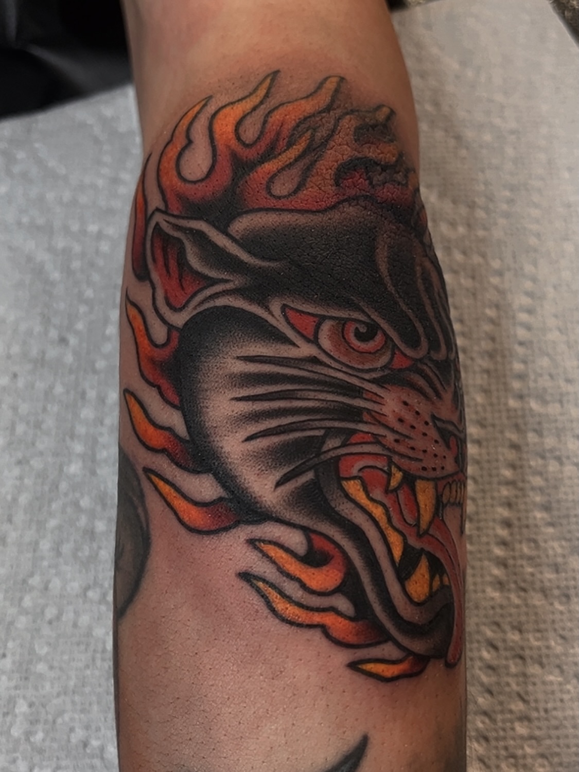Flaming tiger head American traditional tattoo on the forearm by Las Vegas Tattoo Artist
