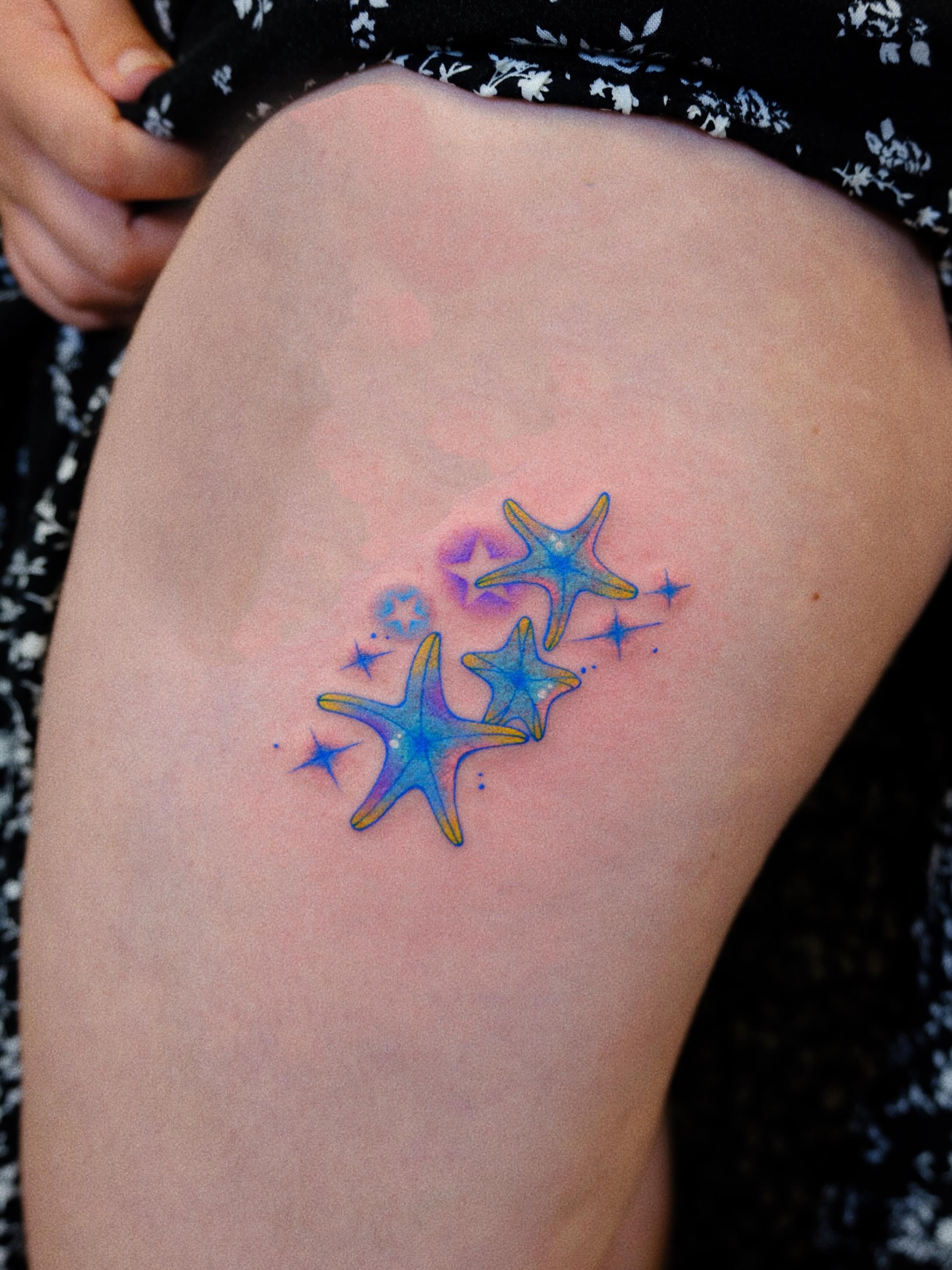 Starfish watercolor tattoo on the thigh by rita_tattooist