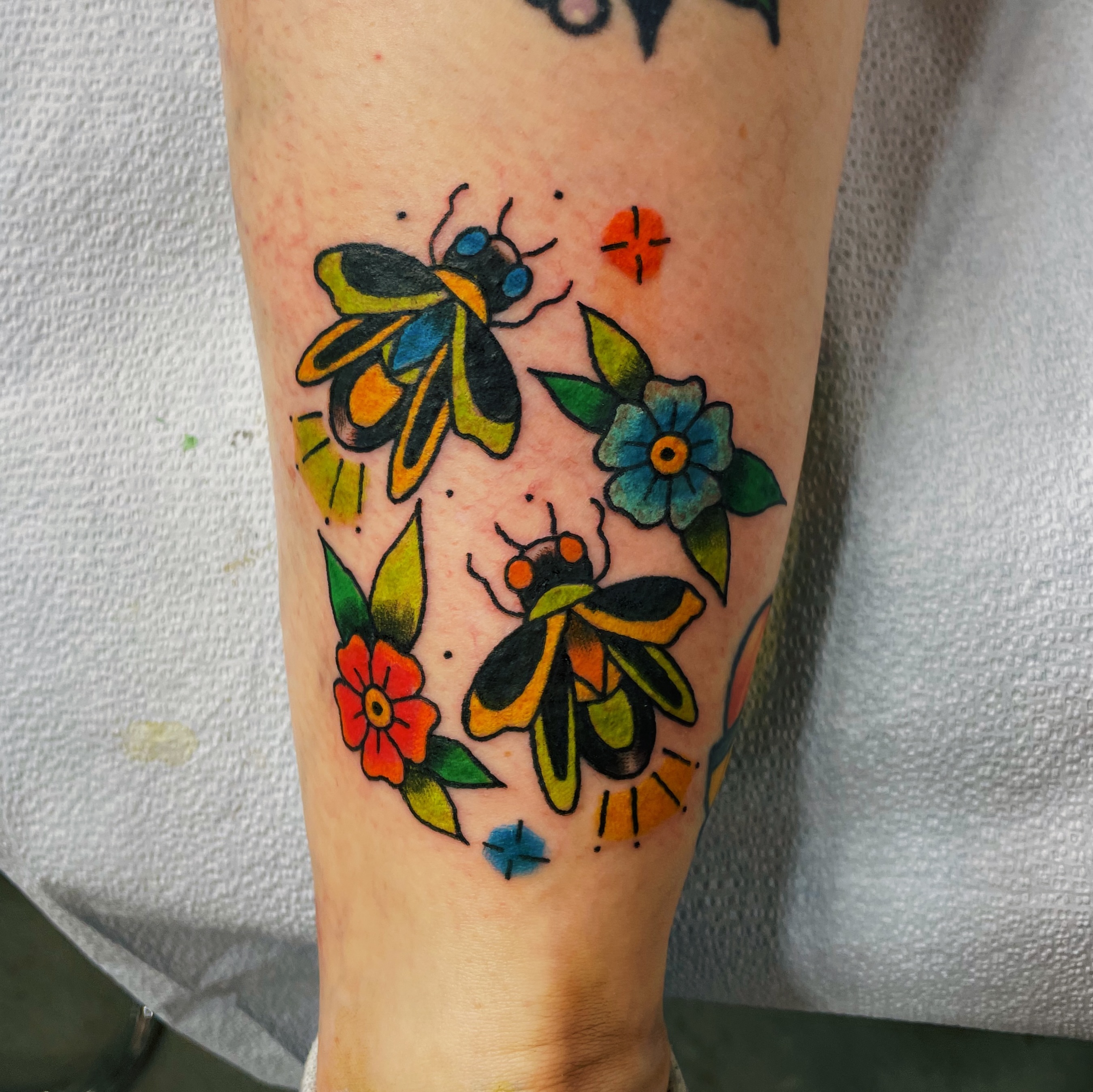 Bees and flowers American traditional tattoo on the forearm by Glume Tattoo