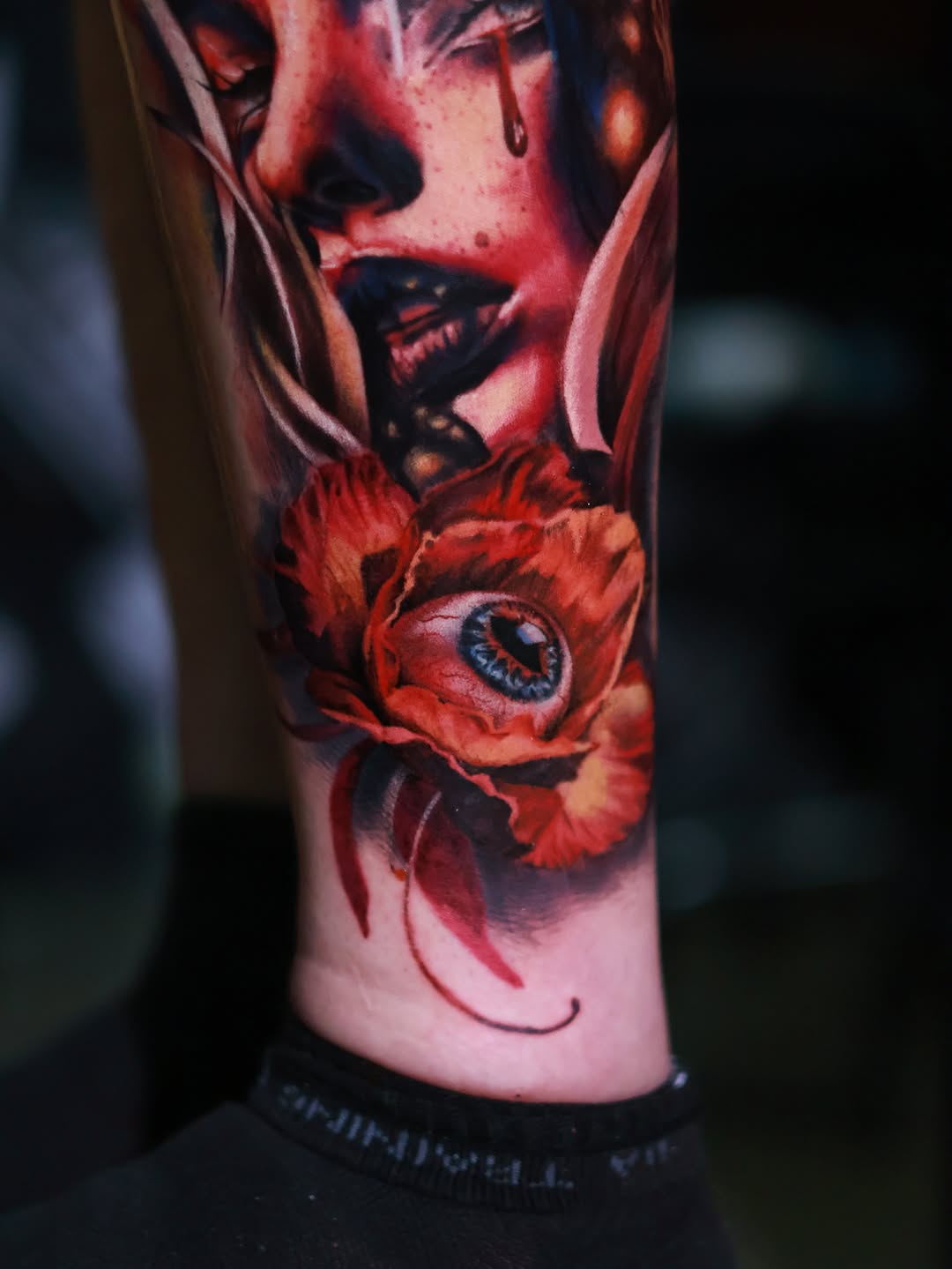 Surreal portrait with eye and flower surrealism tattoo on the forearm by Júlia Sorrino