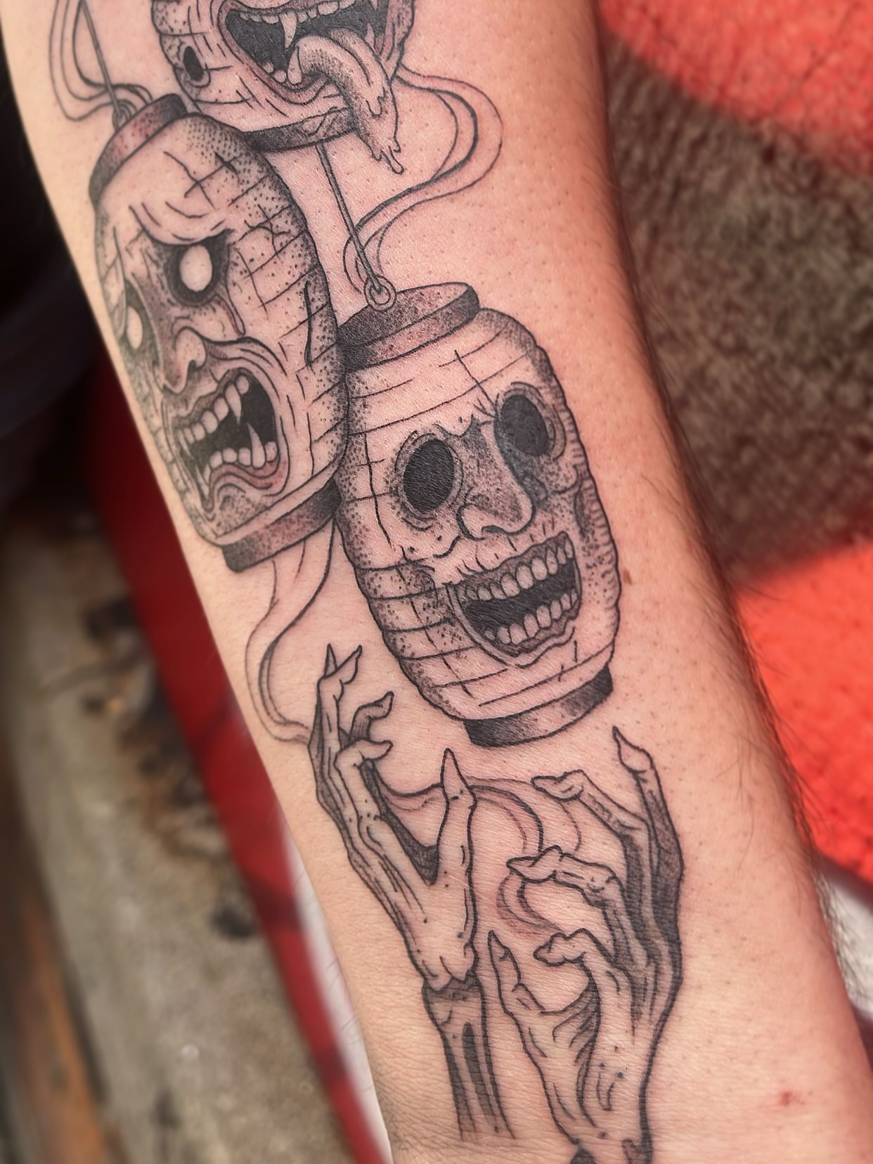 Skulls and hands black and grey tattoo on the forearm by Elle Miller
