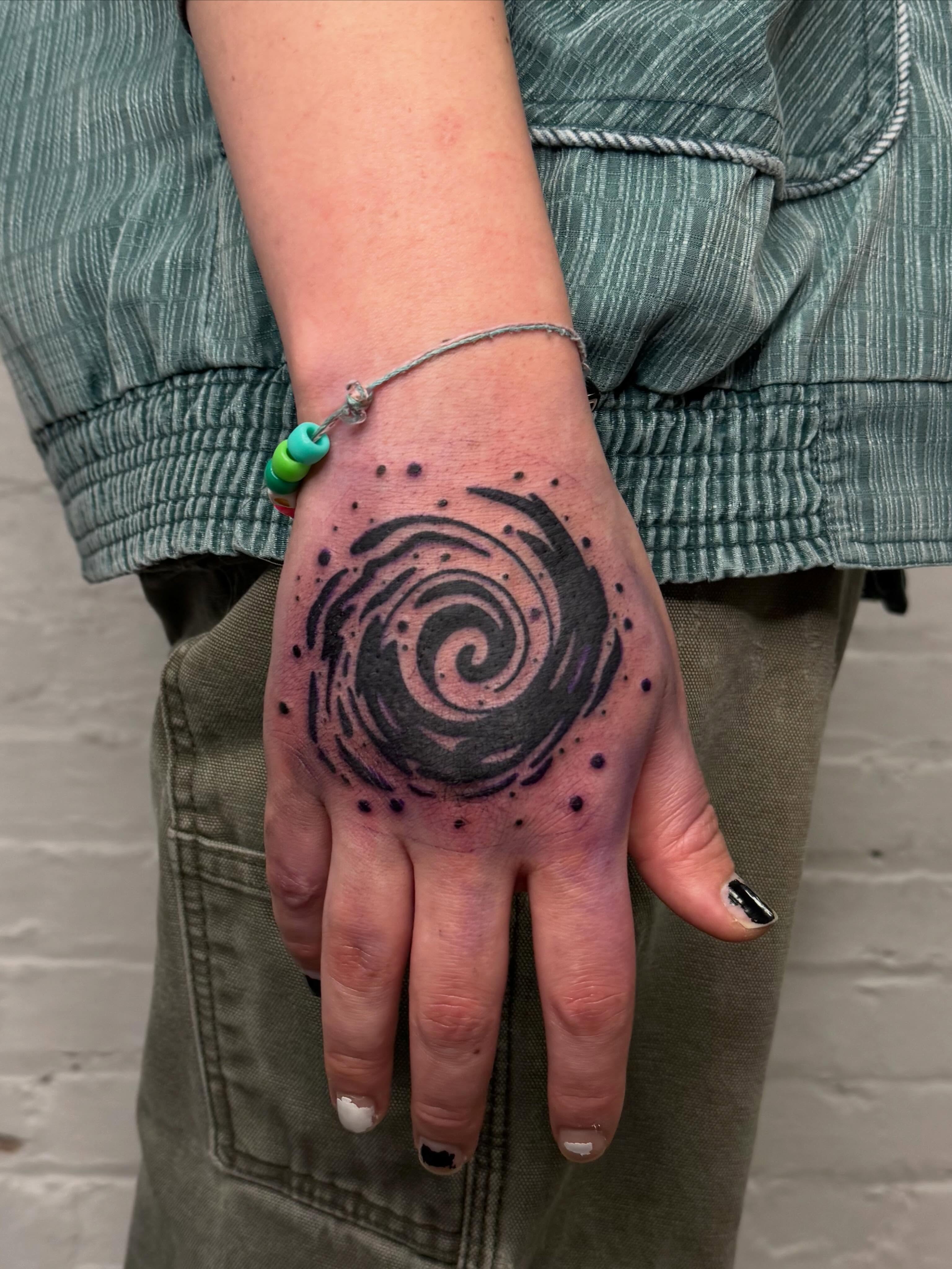 Spiral galaxy dotwork tattoo on the hand by Dennis Patterson