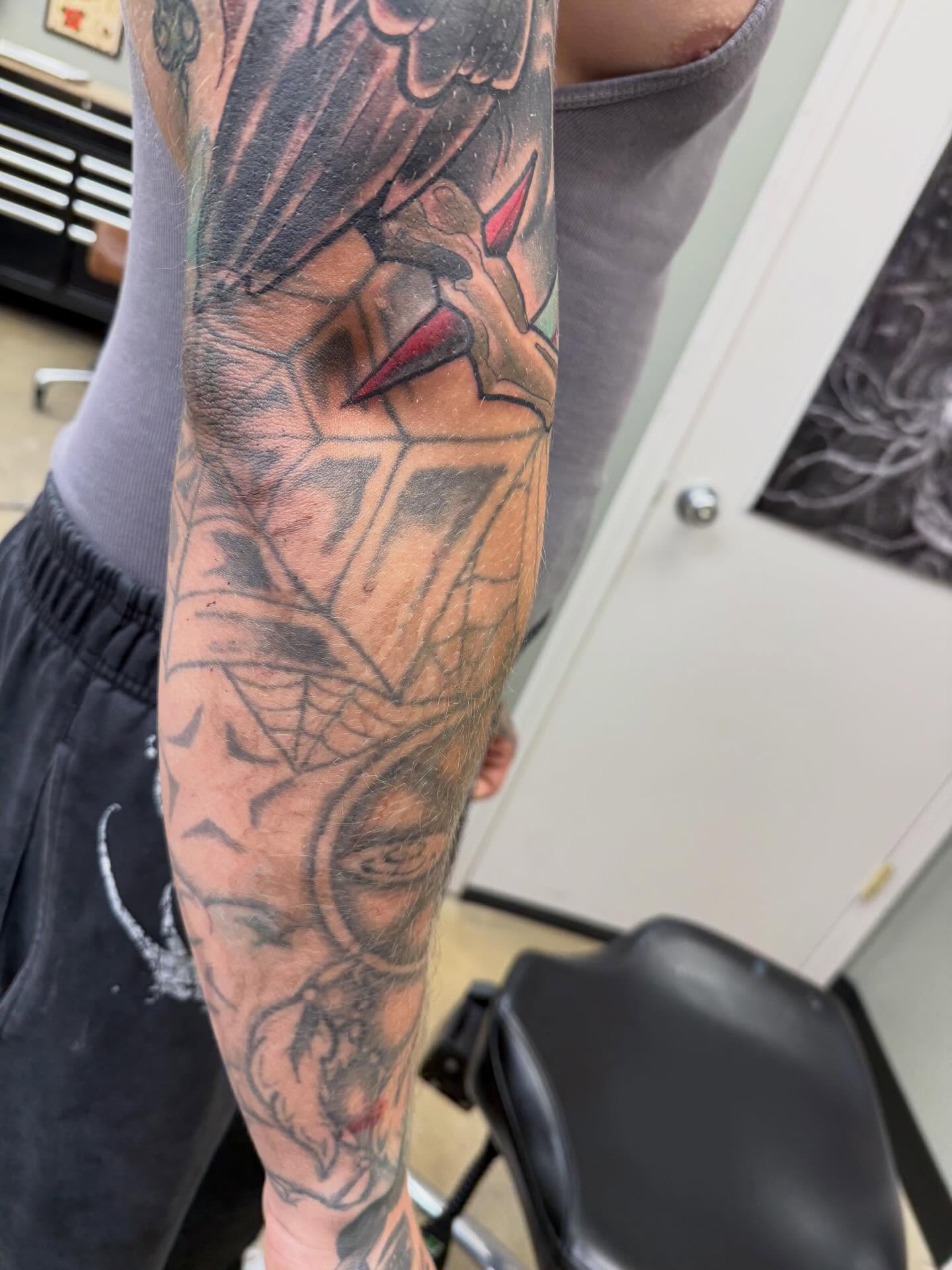 Bird and spiderweb American traditional tattoo on the forearm by Chris Smiseck