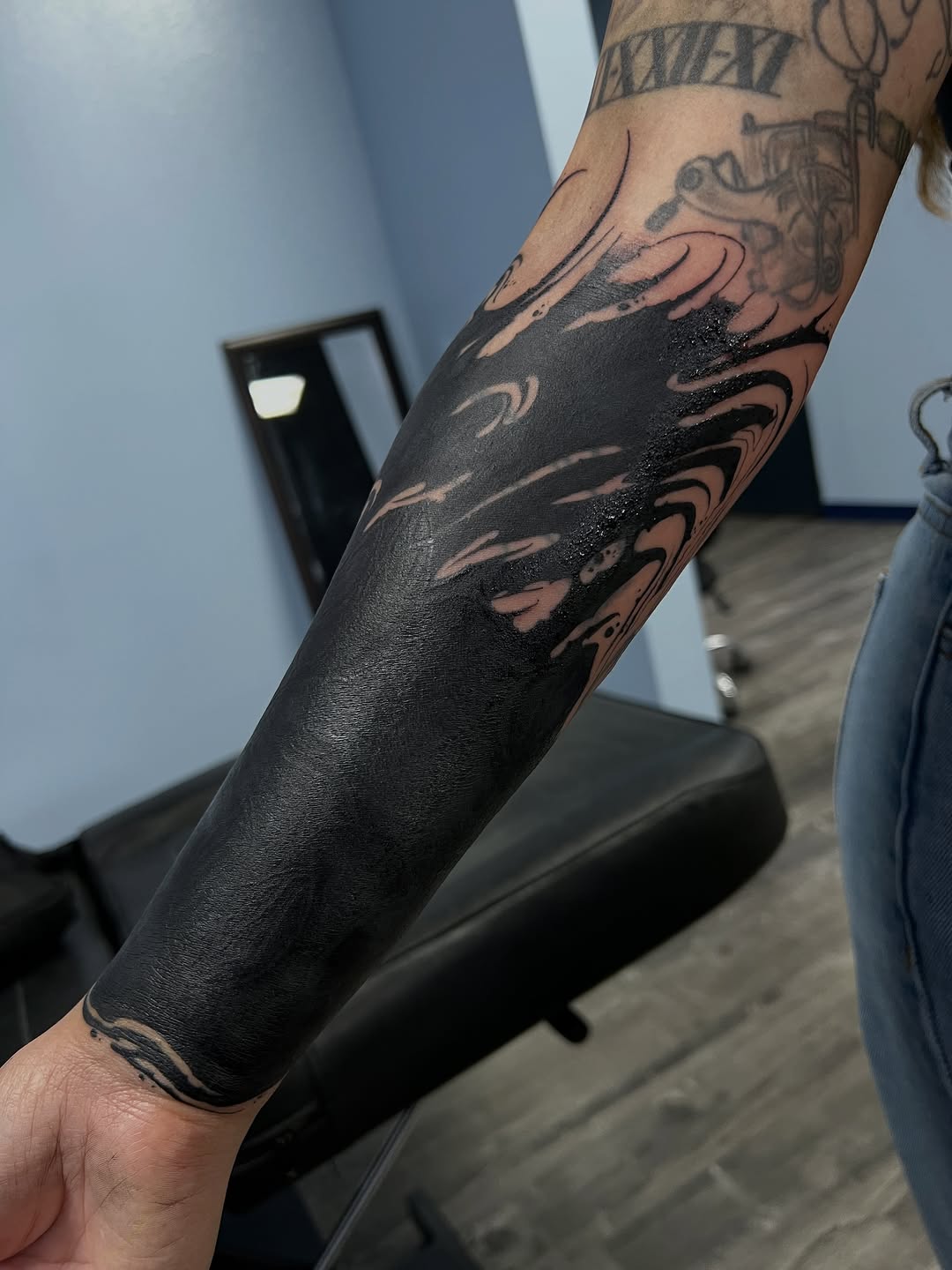 Abstract black fill with waves Japanese tattoo on the forearm by James Foltz