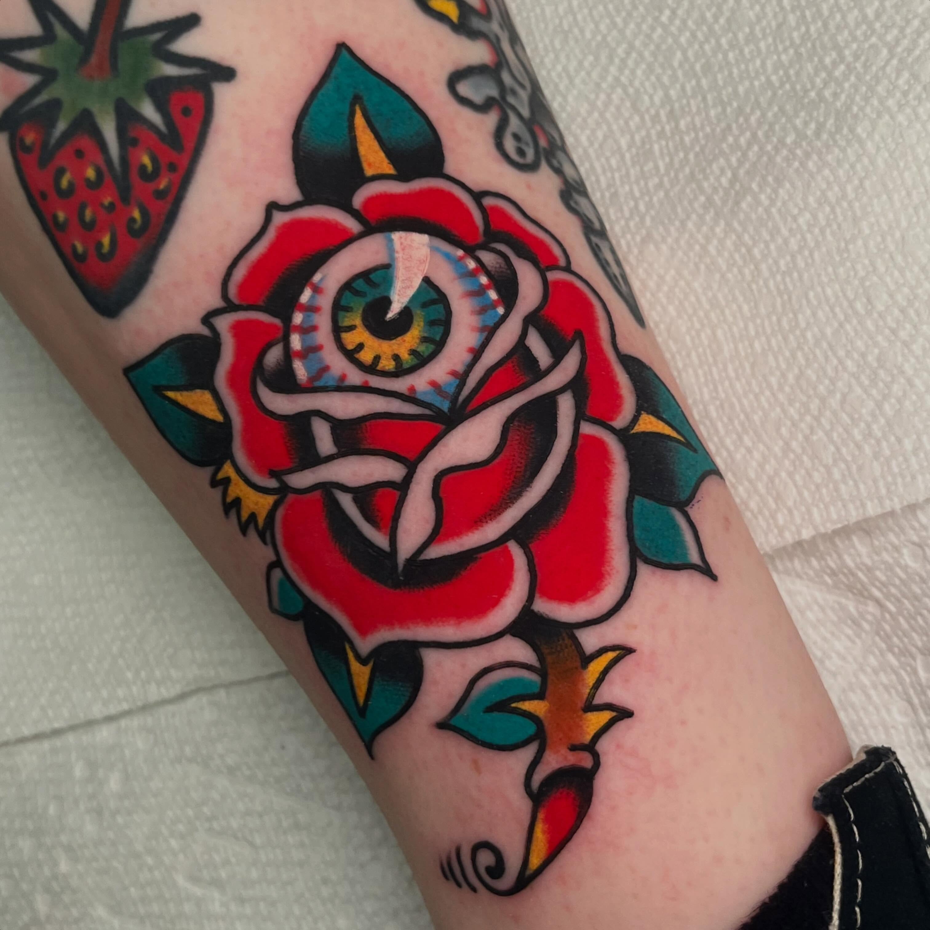 Rose with eye American traditional tattoo on the forearm by Rizzo