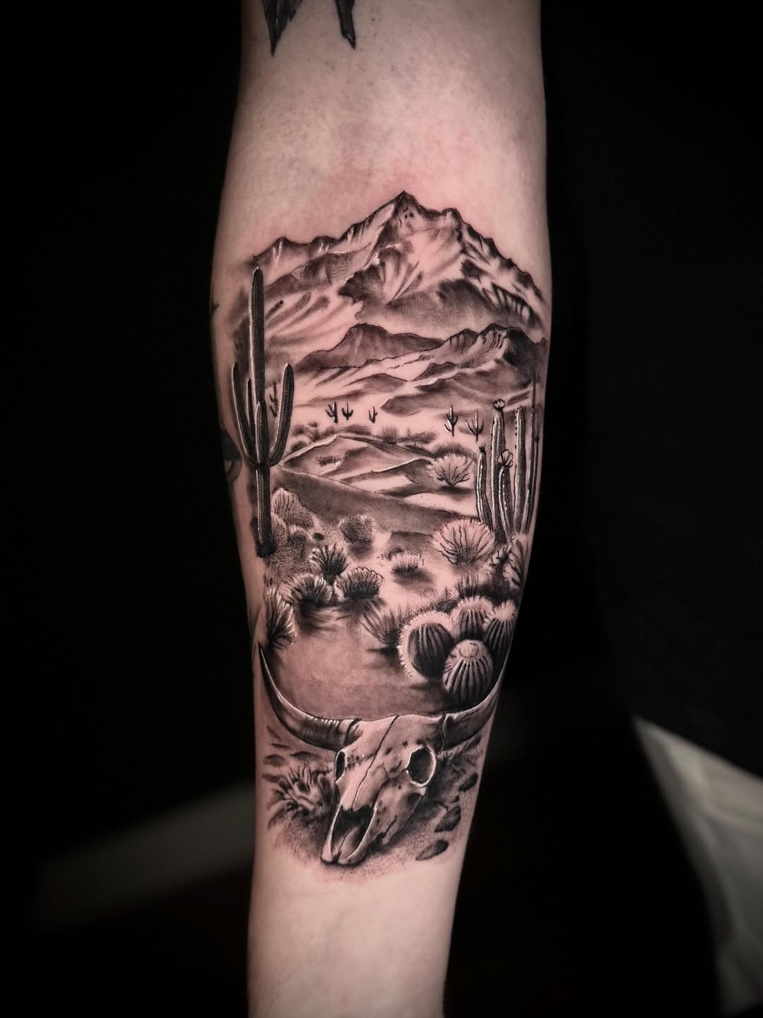 Desert landscape with bull skull fine line tattoo on the forearm by Terence Taylor