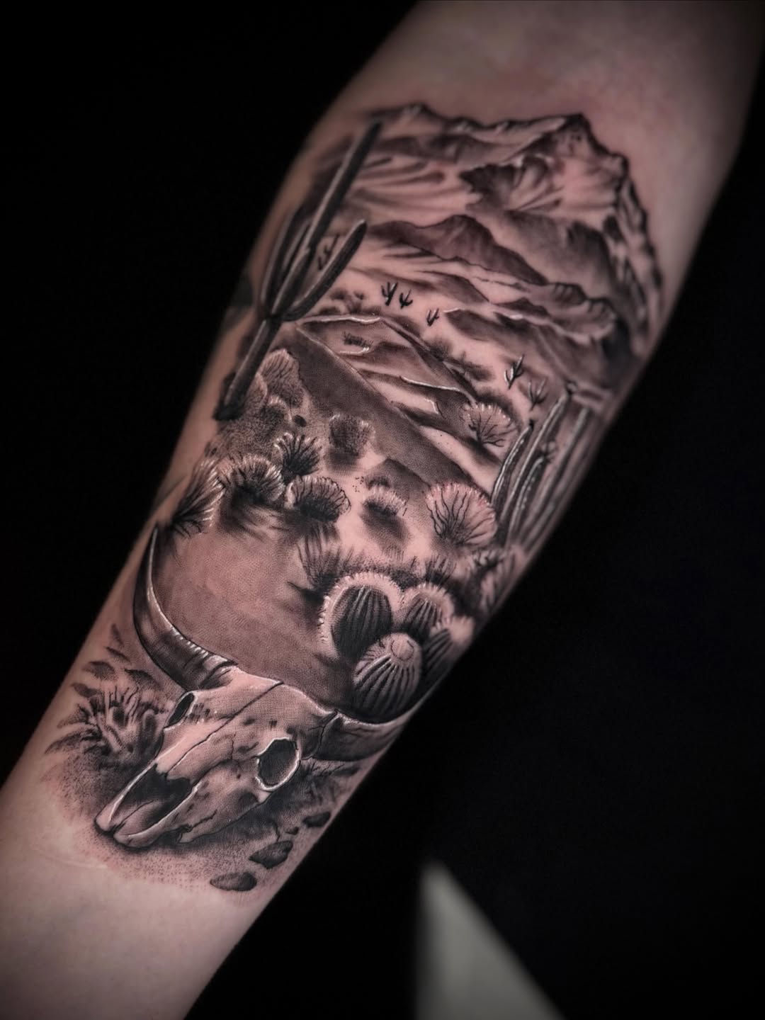 Desert landscape with skull dark art tattoo on the forearm by Terence Taylor