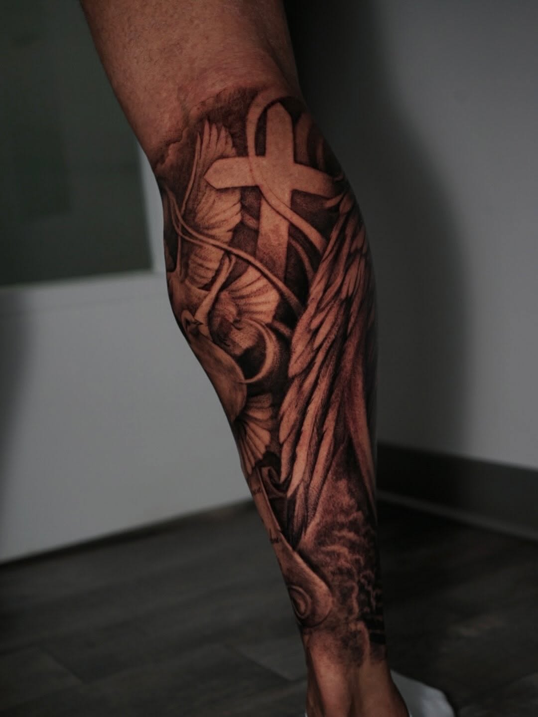 Cross with doves and wings realism tattoo on the forearm by Sabrina Lakhaysy, Fort Worth, Texas