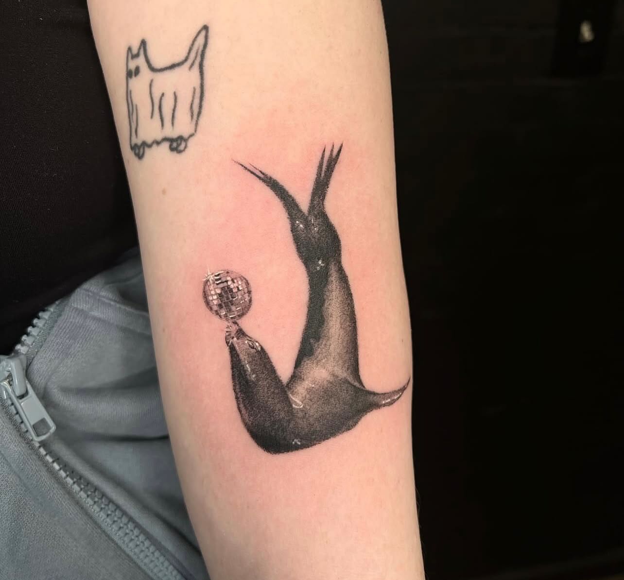 Seal with disco ball realism tattoo on the forearm by Ebony Robinson, Austintown, Ohio