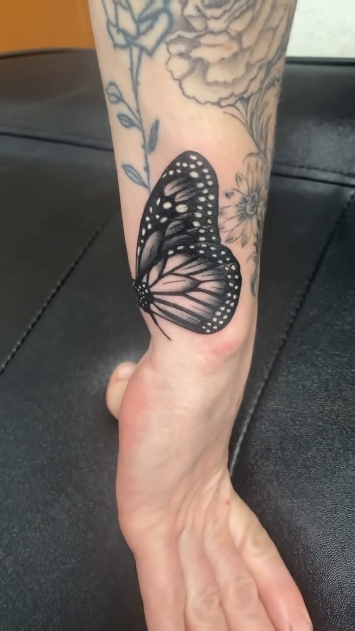 Monarch butterfly on a branch fine line tattoo on the forearm by Timothy Murtaugh