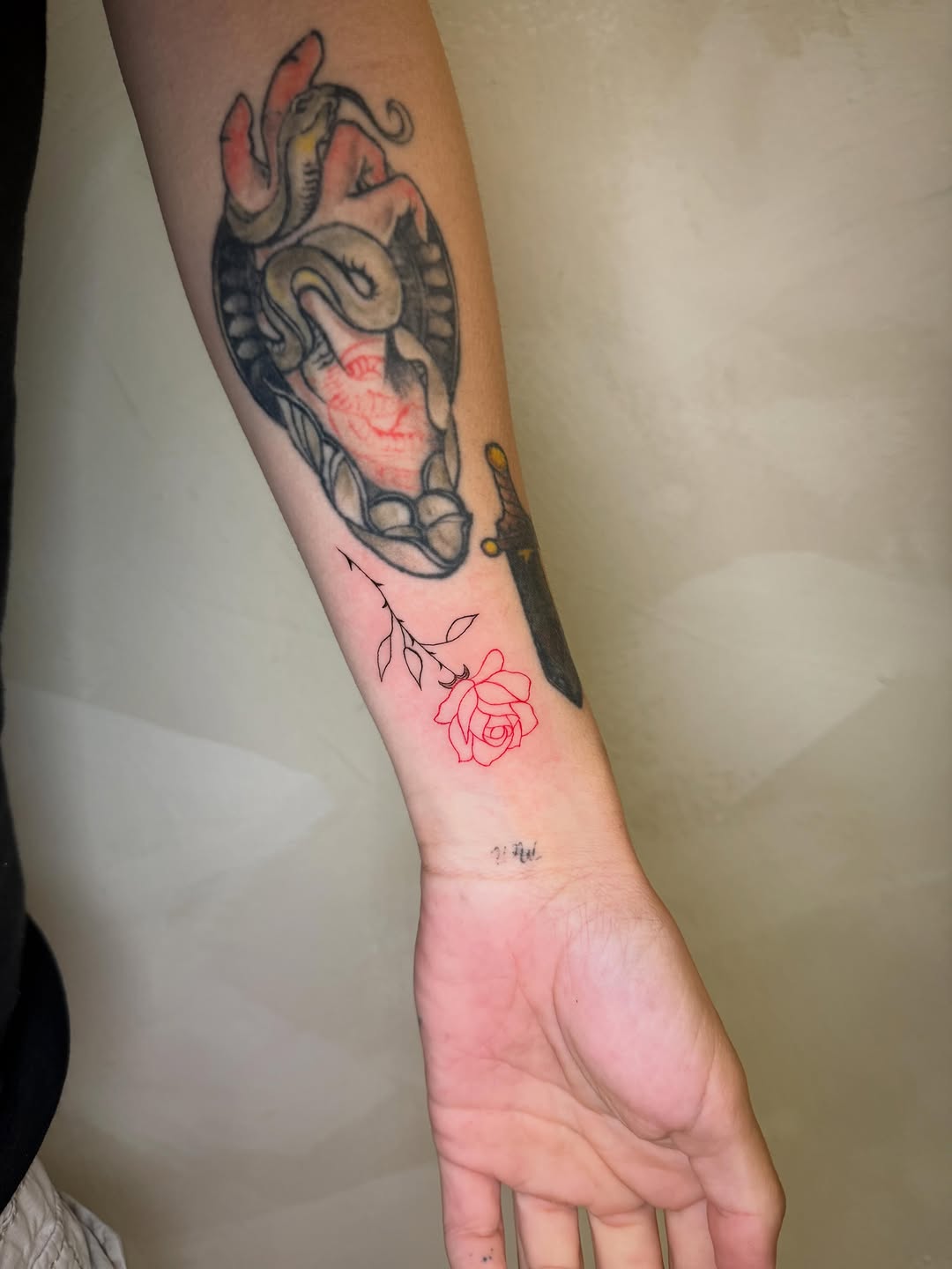 Heart with snake and rose neo-traditional tattoo on the forearm by Danny Garcia