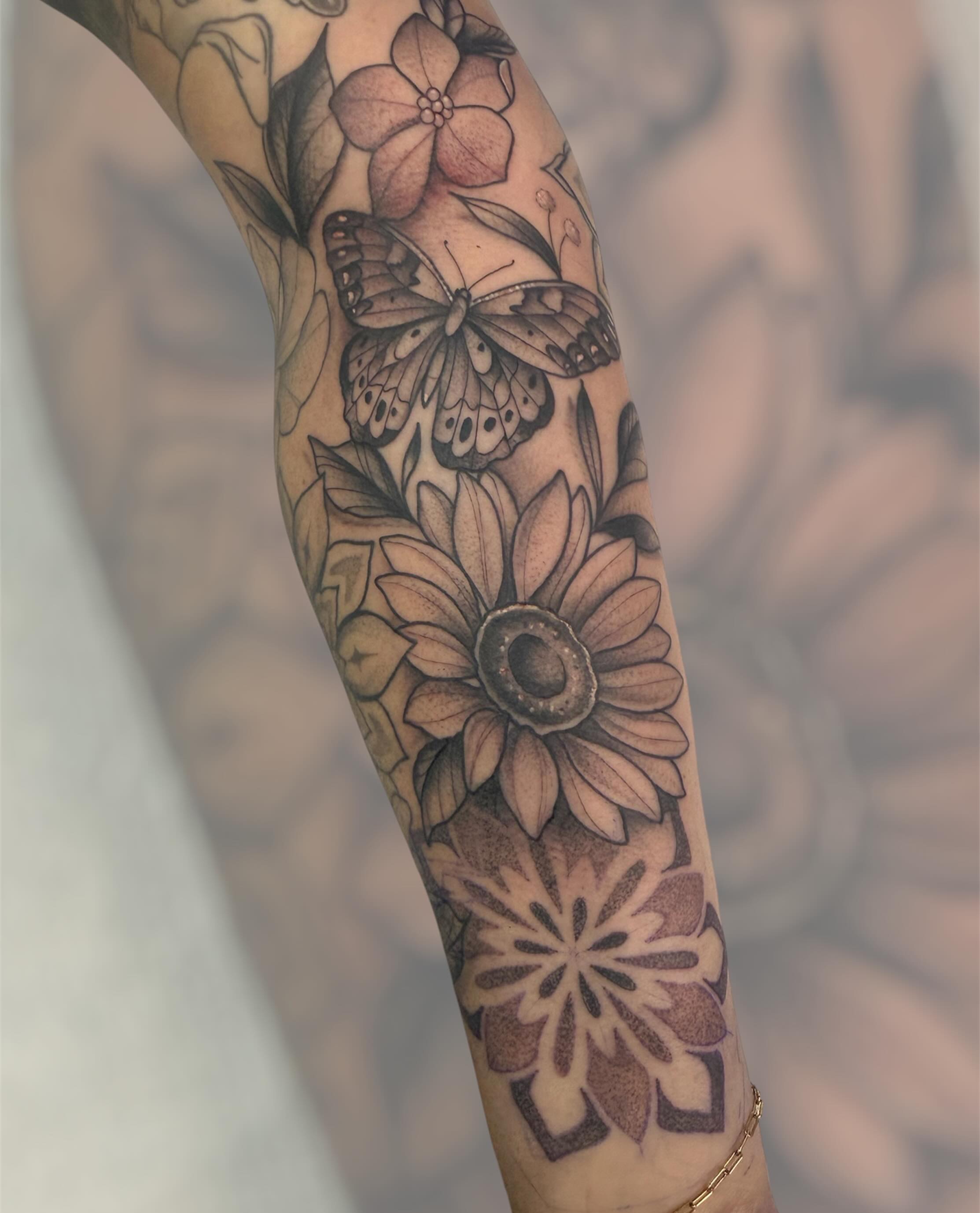 Flowers and butterfly realism tattoo on the forearm by Dameetra Davis