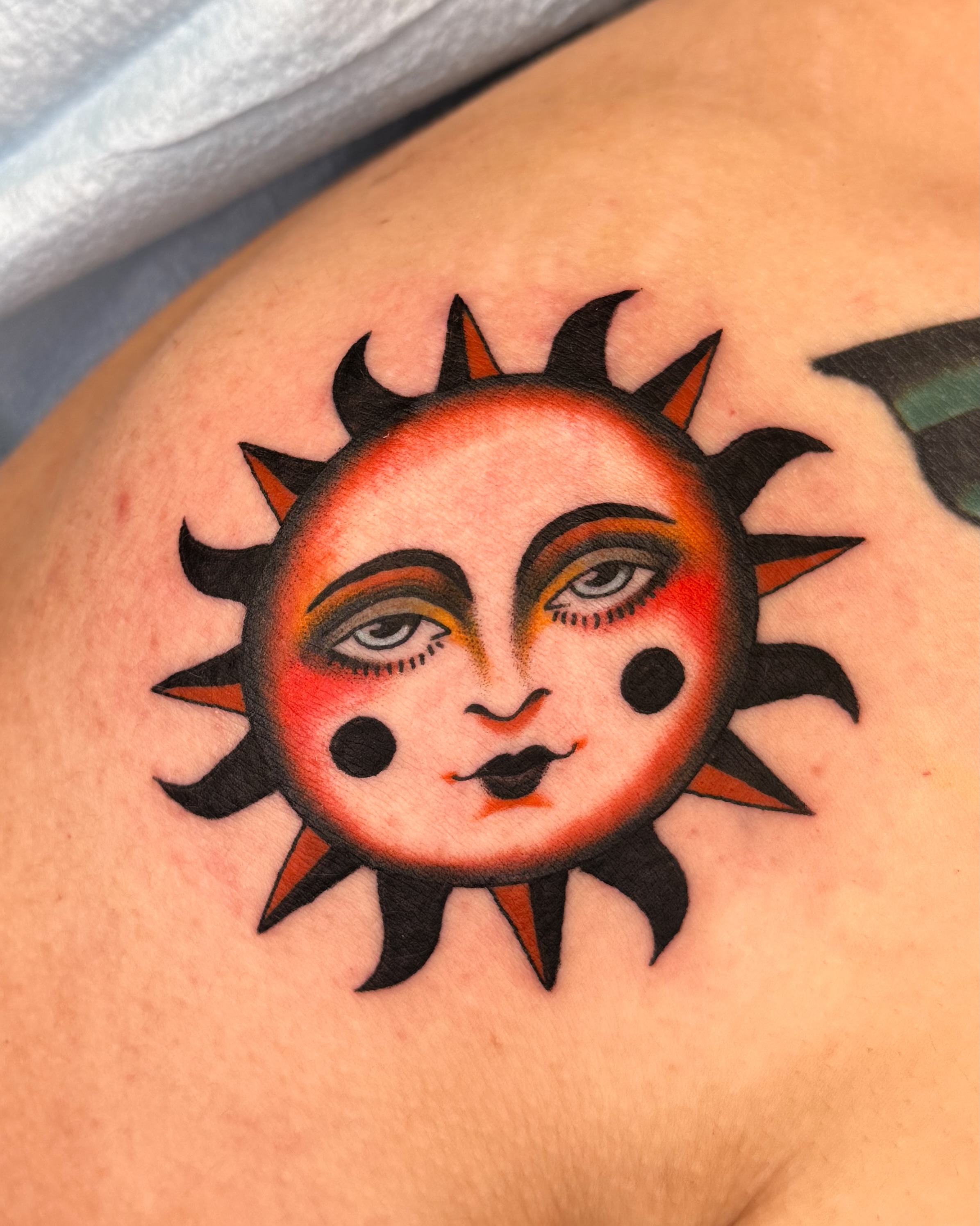 Sun face American traditional tattoo on the shoulder by Allie Barringer