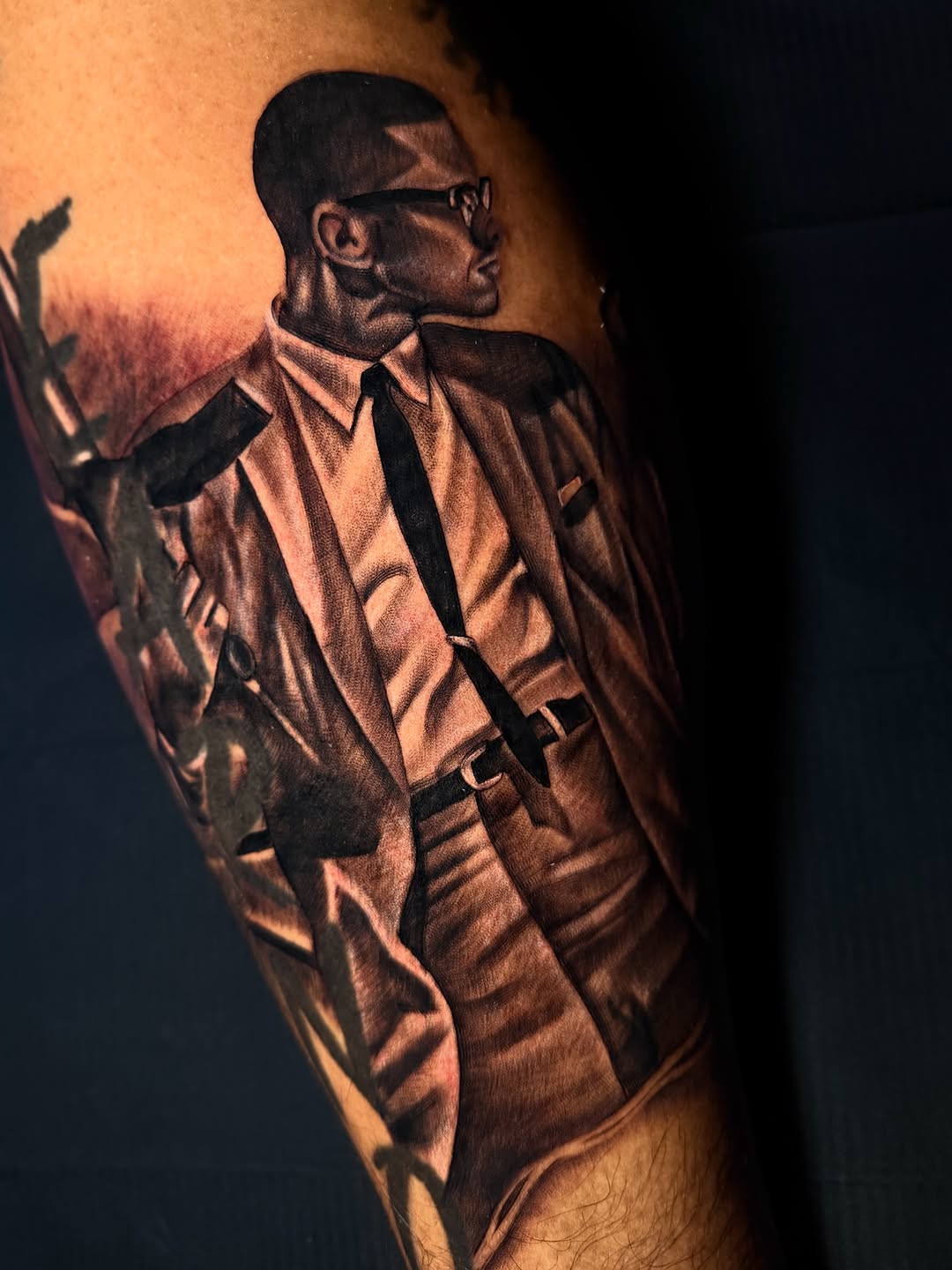 Portrait of Malcolm X realism tattoo on the forearm by Vondrae