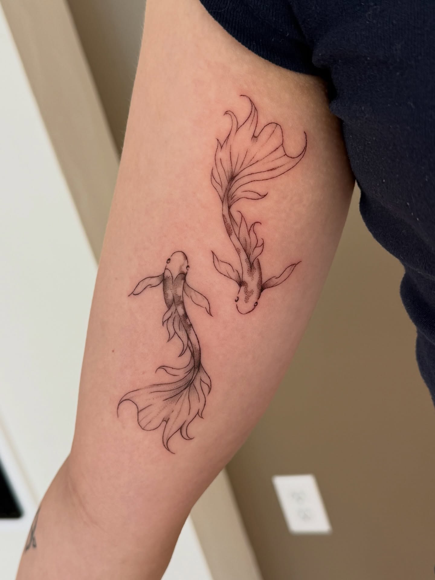 Koi fish fine line tattoo on the forearm by Fine Line Tattoos