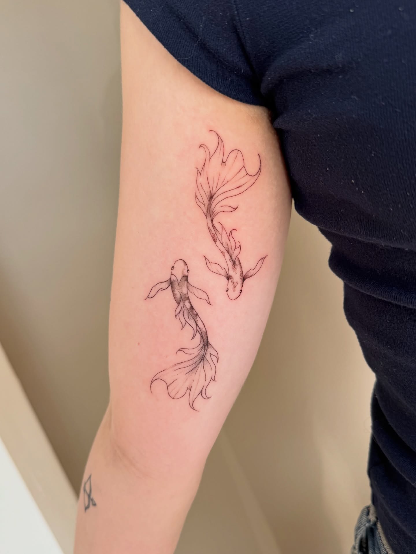 Koi fish black and grey tattoo on the forearm by Fine Line Tattoos