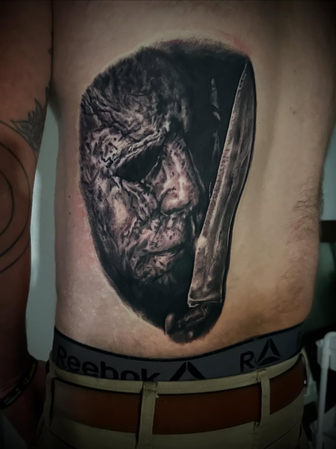 Michael Myers mask realism tattoo on the torso by Neil5one3