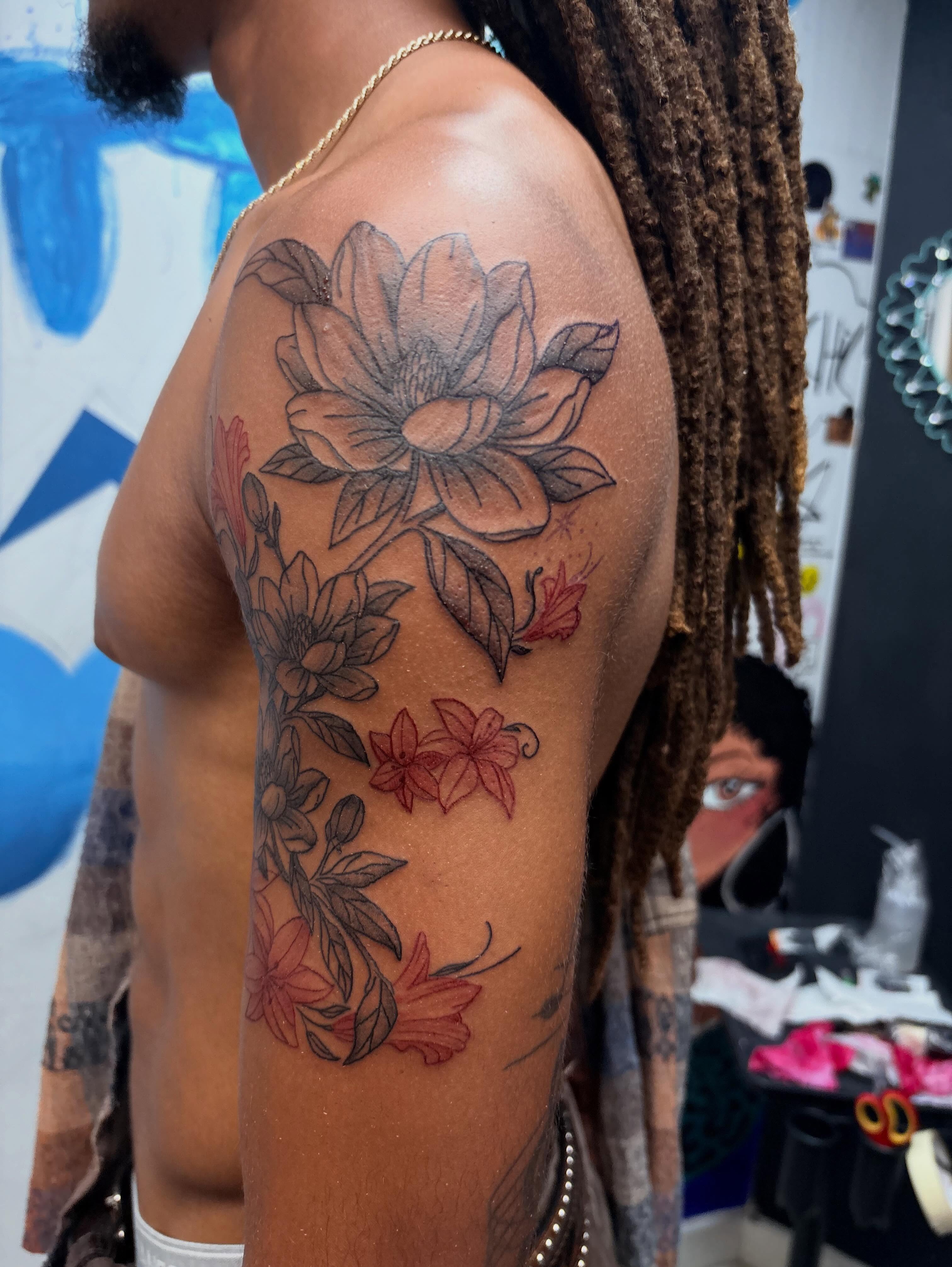 Flower bouquet black and grey tattoo on the upper arm by 𝓚𝓪𝓻𝓶𝓪💫