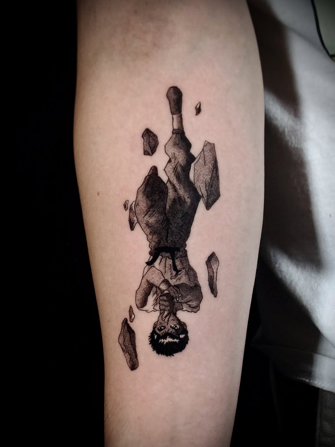 Character falling with rocks anime tattoo on the forearm by Kanya, Alhambra, California