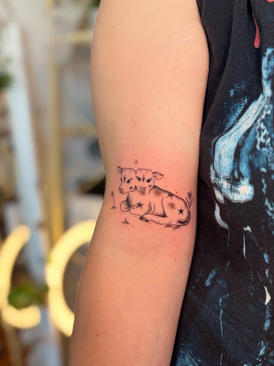 Two-headed cow fine line tattoo on the forearm by carla sofia