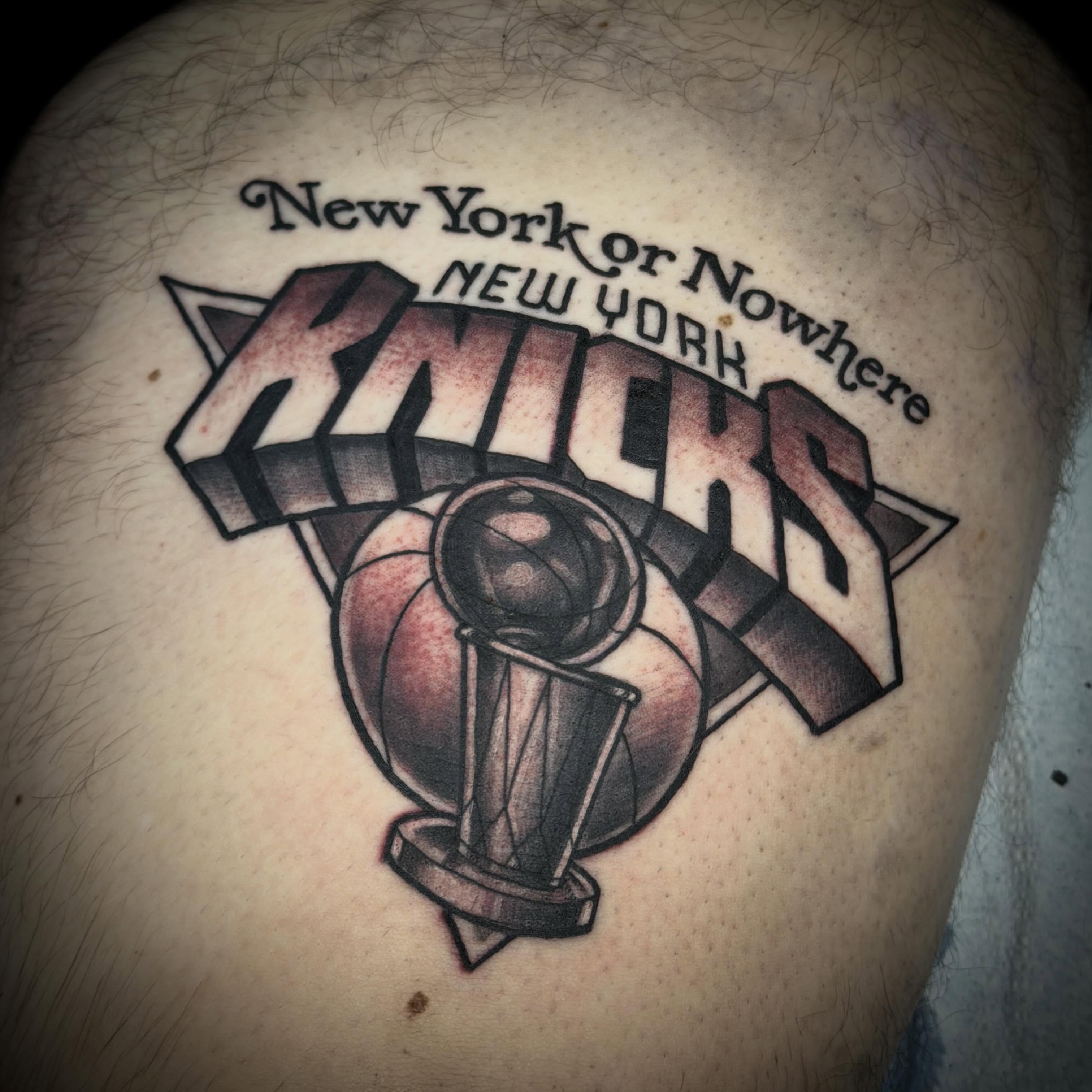 New York Knicks logo black and grey tattoo on the thigh by Cory Haberman