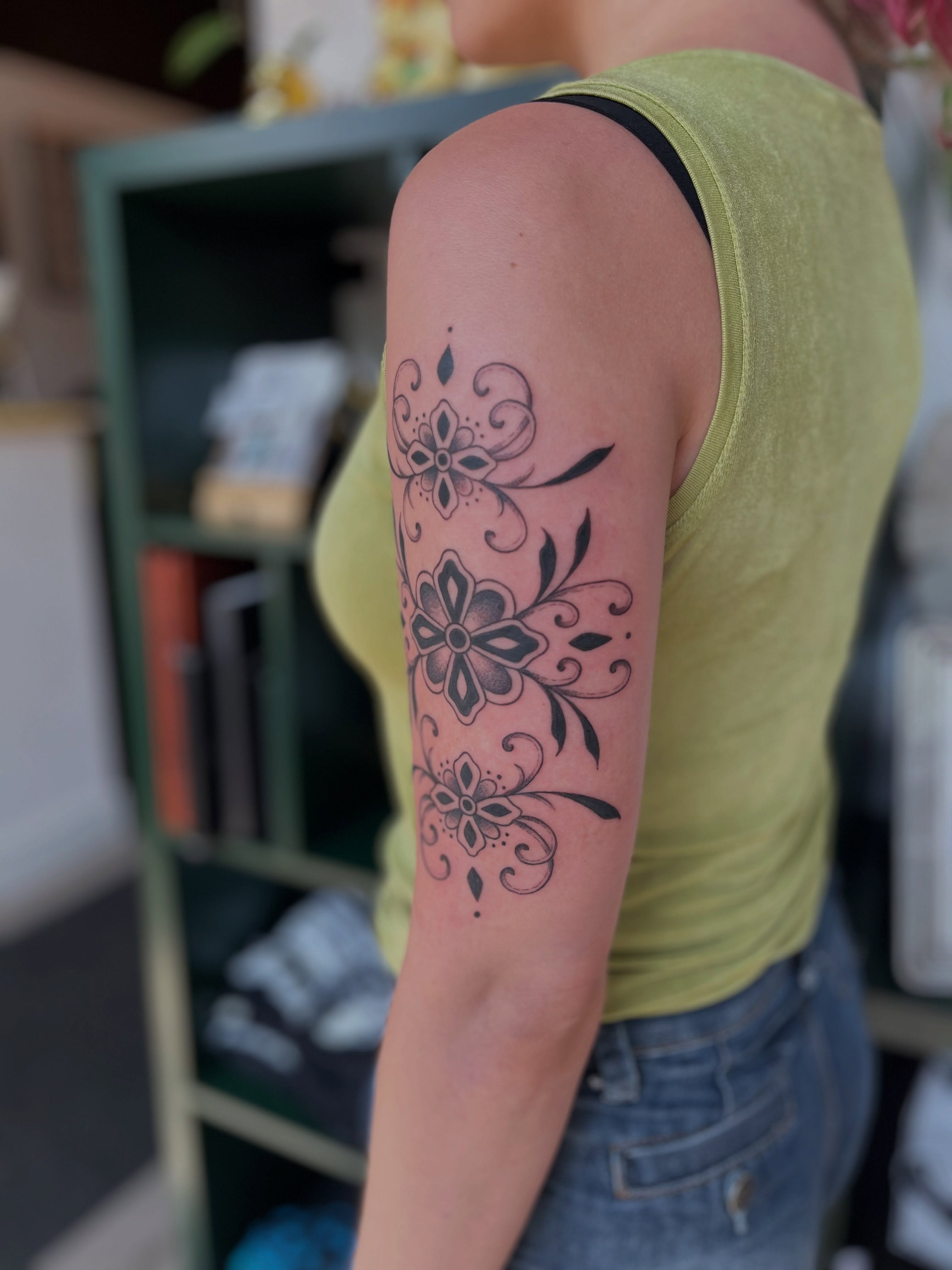 Floral design black and grey tattoo on the forearm by Maddy Anthony