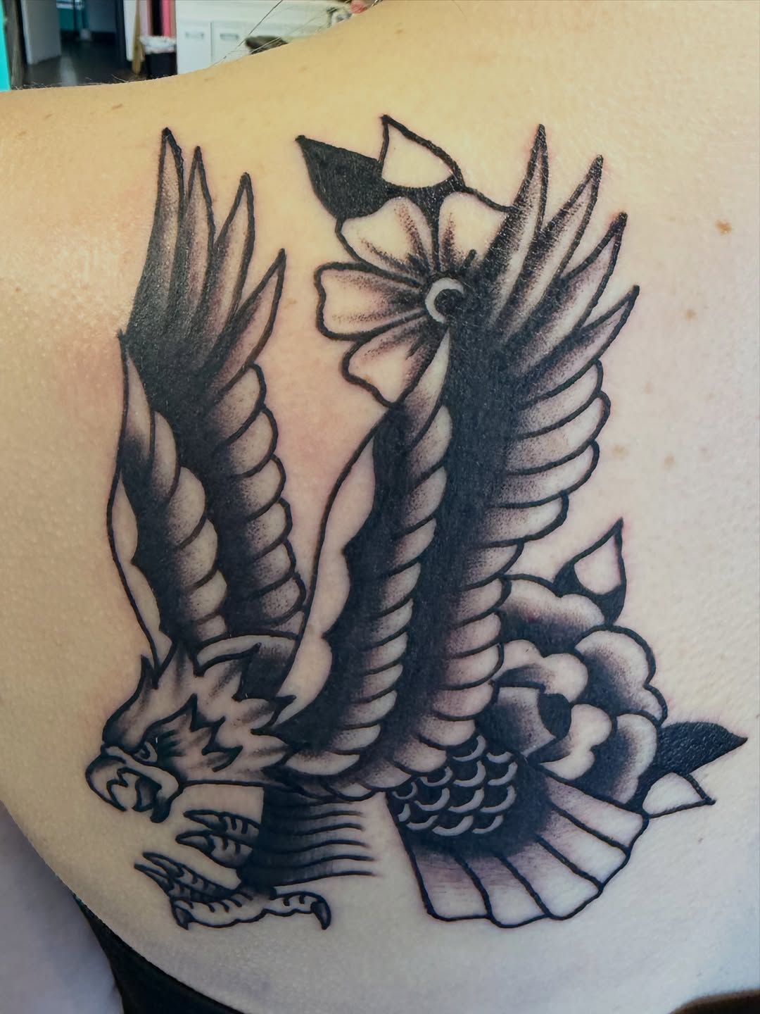 Eagle and flowers fine line tattoo on the back by Nick Tumminello