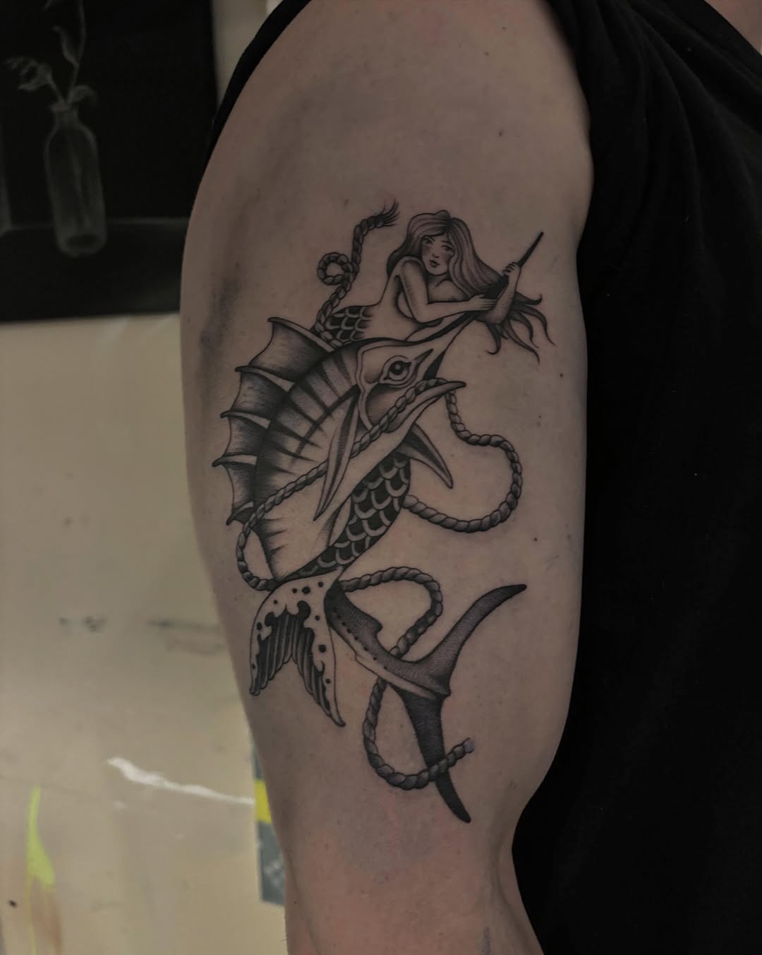 Mermaid and fish black and grey tattoo on the forearm by Emma Cotter